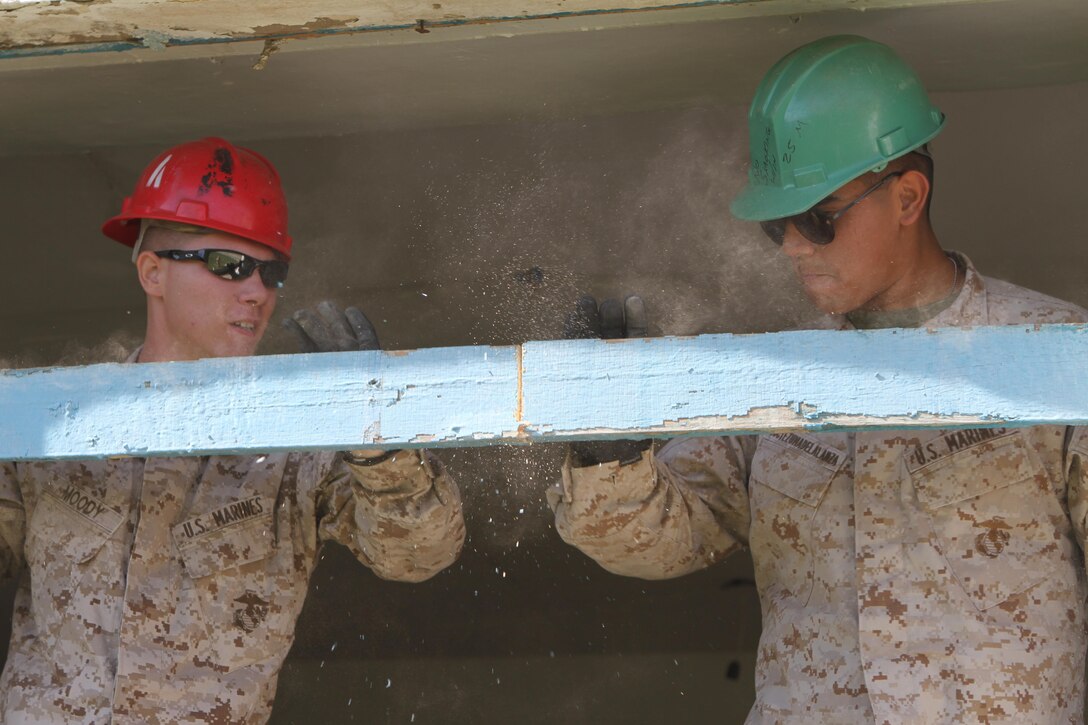 U.S. Marines Lance Cpl. Braxton R. Moody (left) and Private First Class Ismael Moctezumadelalanza with 9th Engineer Support Battalion works to clear debris from a window frame during renovation work on Erdmiin Oyun High School as part of Exercise Khaan Quest in the Nalaikh District of Ulaanbaatar, Mongolia, July 20, 2013. Khaan Quest is a regularly scheduled multinational exercise co sponsored this year by U.S. Marine Corps Forces, Pacific, and hosted annually by the Mongolian Armed Forces, designed to promote regional peace and security.