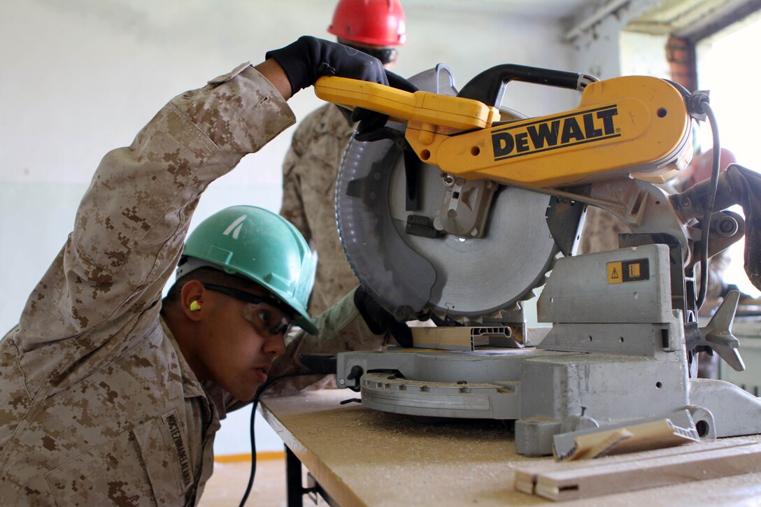 Pfc. Ismael Moctezumadelalanza, a combat engineer with 9th Engineer Support Battalion, 3rd Marine Logistics Group, lines up a cut with a chopsaw during renovation work on Erdmiin Oyun High School as part of Exercise Khaan Quest in the Nalaikh District of Ulaanbaatar, Mongolia, July 22.  Khaan Quest is a regularly scheduled multinational exercise co sponsored this year by U.S. Marine Corps Forces, Pacific, and hosted annually by the Mongolian Armed Forces, designed to promote regional peace and security.