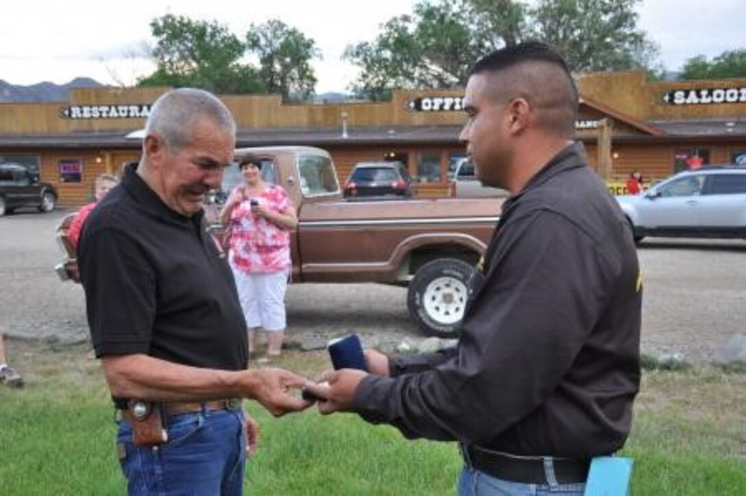 Former Marine Sgt. Gary Brown (left) receives the official Marine Corps Mounted Color Guard belt buckle from Sgt. Edgar Torrealba, the staff noncommissioned officer in charge of the MCG, July 5.
