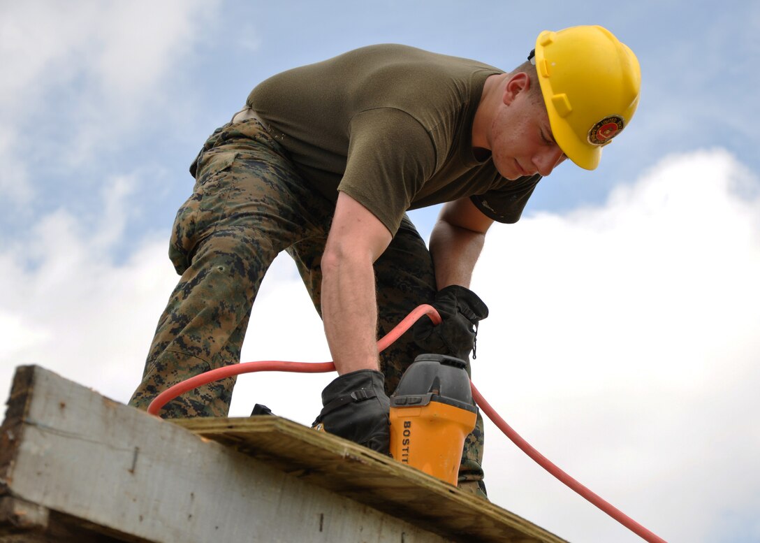 U.S. Marine Corps Cpl. John Yamuni, combat engineer from Marine Wing Support Squadron 471, installs roof decking to repair the Hattieville Government Pre-School, June 4, as part of exercise New Horizons. Engineers from both the U.S. and Belize are constructing various structures at schools throughout Belize as part of the exercise. (U.S. Air Force photo by Capt. Holly Hess/Released)