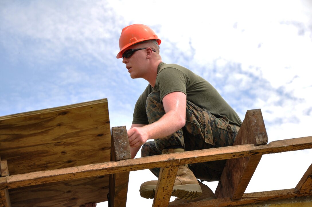 U.S. Marine Corps Lance Cpl. Timothy Brotherton, a combat engineer from Marine Wing Support Squadron 472, installs roof decking to repair the Hattieville Government Pre-School, June 4, as part of exercise New Horizons.  Engineers from both the U.S. and Belize are constructing various structures at schools throughout Belize as part of the exercise. (U.S. Air Force photo by Capt. Holly Hess/Released)