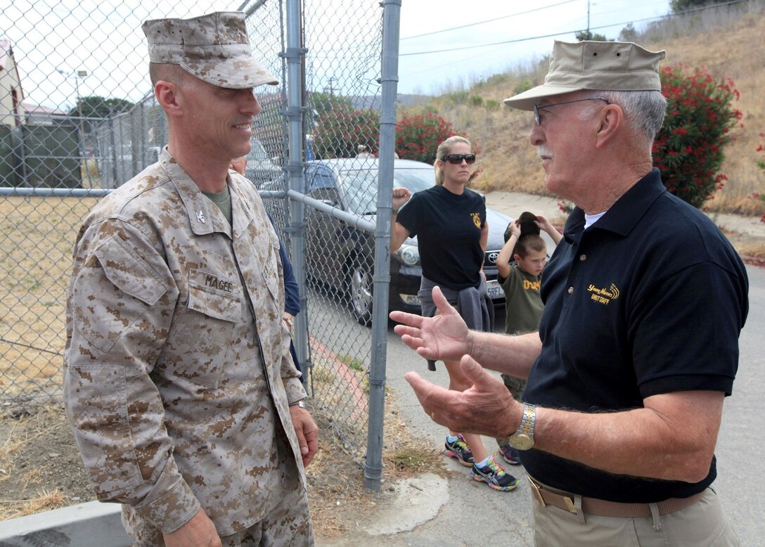 Col. Sean Magee and Sgt. Maj. Michael D. Magee (ret.) discuss the training program of the Southeast County Young Marines outside of the 1st Marine Regiment marksmanship training unit at Camp Pendleton, Calif., July 19. Both father and son work together and offer their military experience for the Young Marine program.