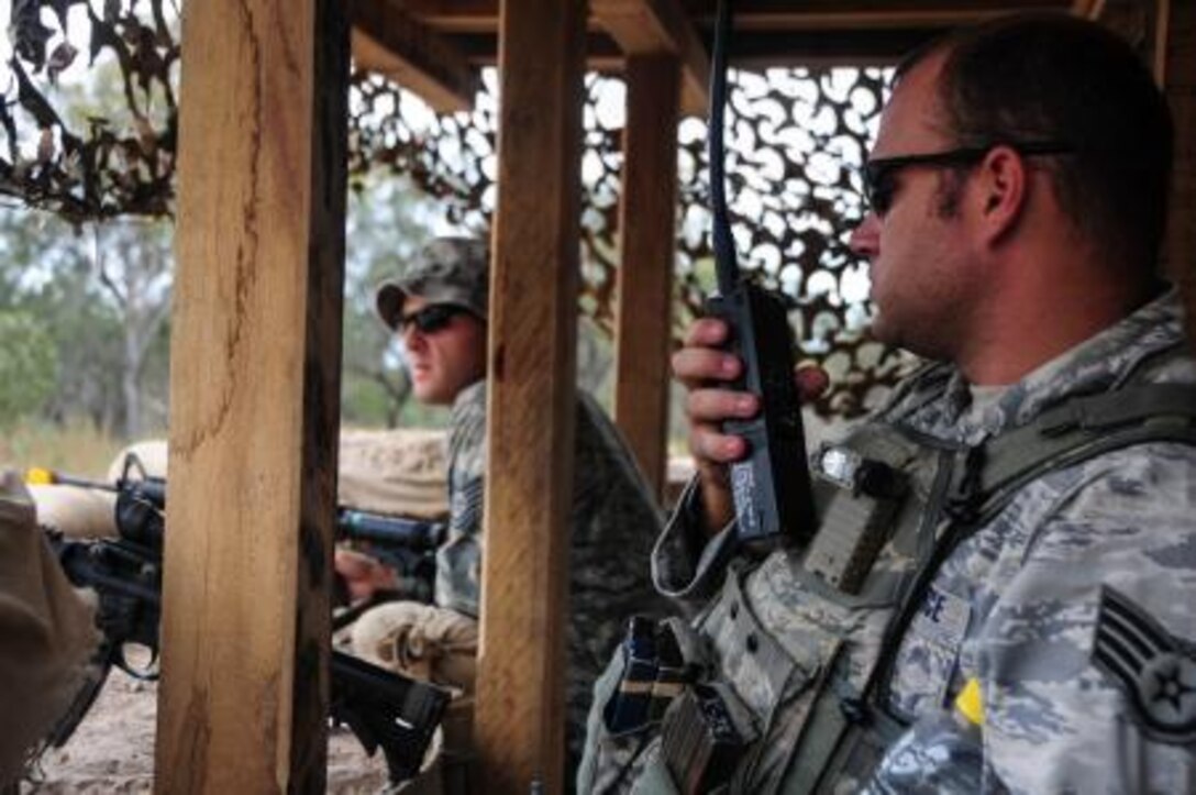 Staff Sgt. James Foster, 736th Security Forces Squadron combat arms noncommissioned officer in charge, checks the status of an entry control point at Williamson Airfield using radio communications July 22 during Talisman Saber 2013. The 736th SFS and 36th Mobility Response Squadron are part of the 36th Contingency Response Group, Andersen Air Force Base, Guam. The 36th CRG assumed command and control of the airfield from the 1st Battalion, 501st Parachute Infantry Regiment, 4th Brigade Combat Team, 25th Infantry Division (Airborne) and turned over command to the Royal Australian Air Force as part of a multiphase combined joint operation. Talisman Saber was designed to utilize a realistic scenario to train U.S. and Australian forces in planning and executing combined and joint military operations on land, air and sea. (U.S. Air Force photo by Airman 1st Class Marianique Santos/Released)