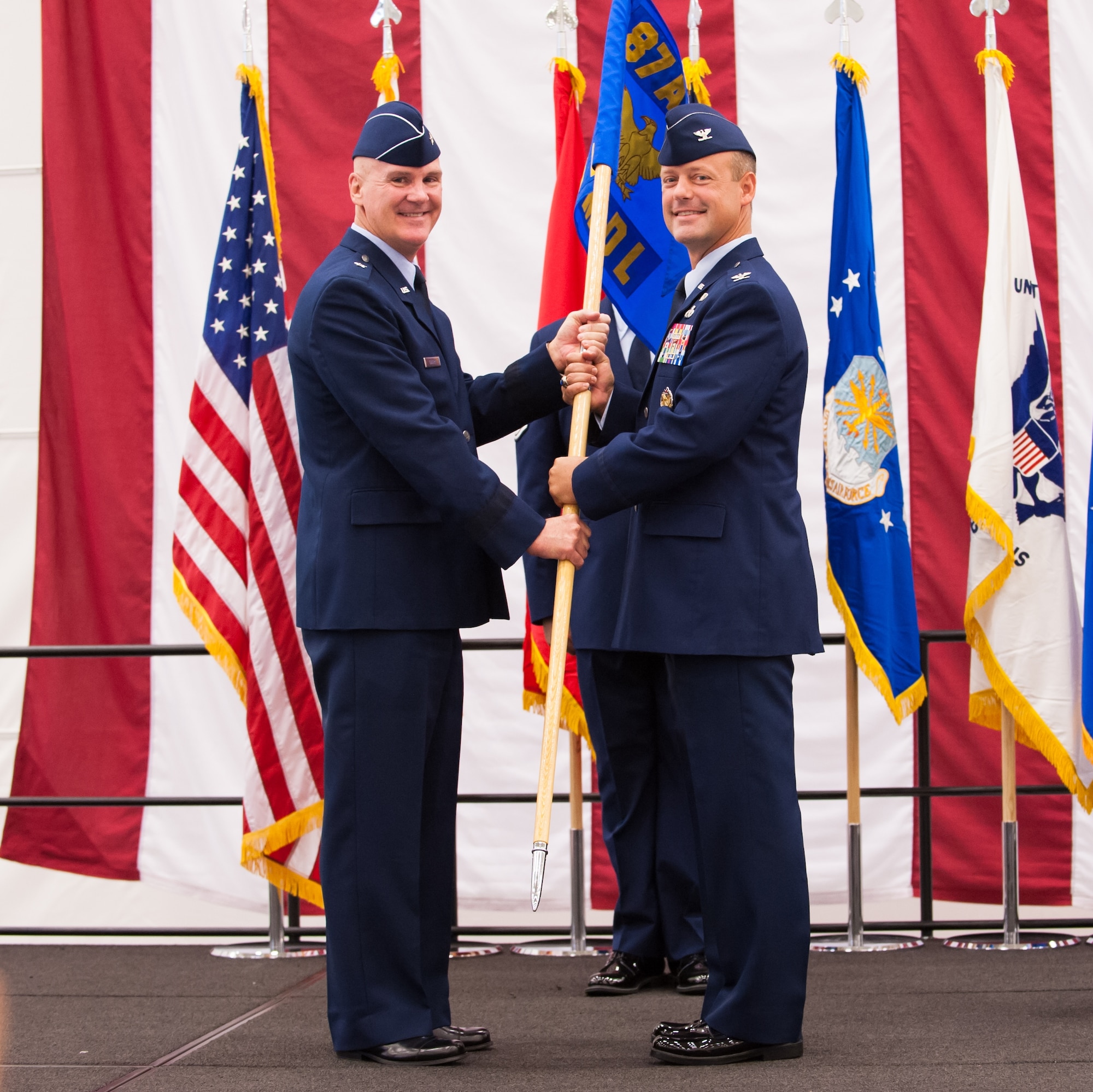Brig. Gen. Randall C. Guthrie, U.S. Air Force Expeditionary Center commander, passes the guidon to Col. James C. Hodges, who takes command during the 87th Air Base Wing Change of Command Ceremony July 25, 2013, in Hanger 3370 on Joint Base McGuire-Dix-Lakehurst, N.J. During the event Col. John M. Wood relinquished command to Hodges. (U.S. Air Force photo by Russ Meseroll/Released)
