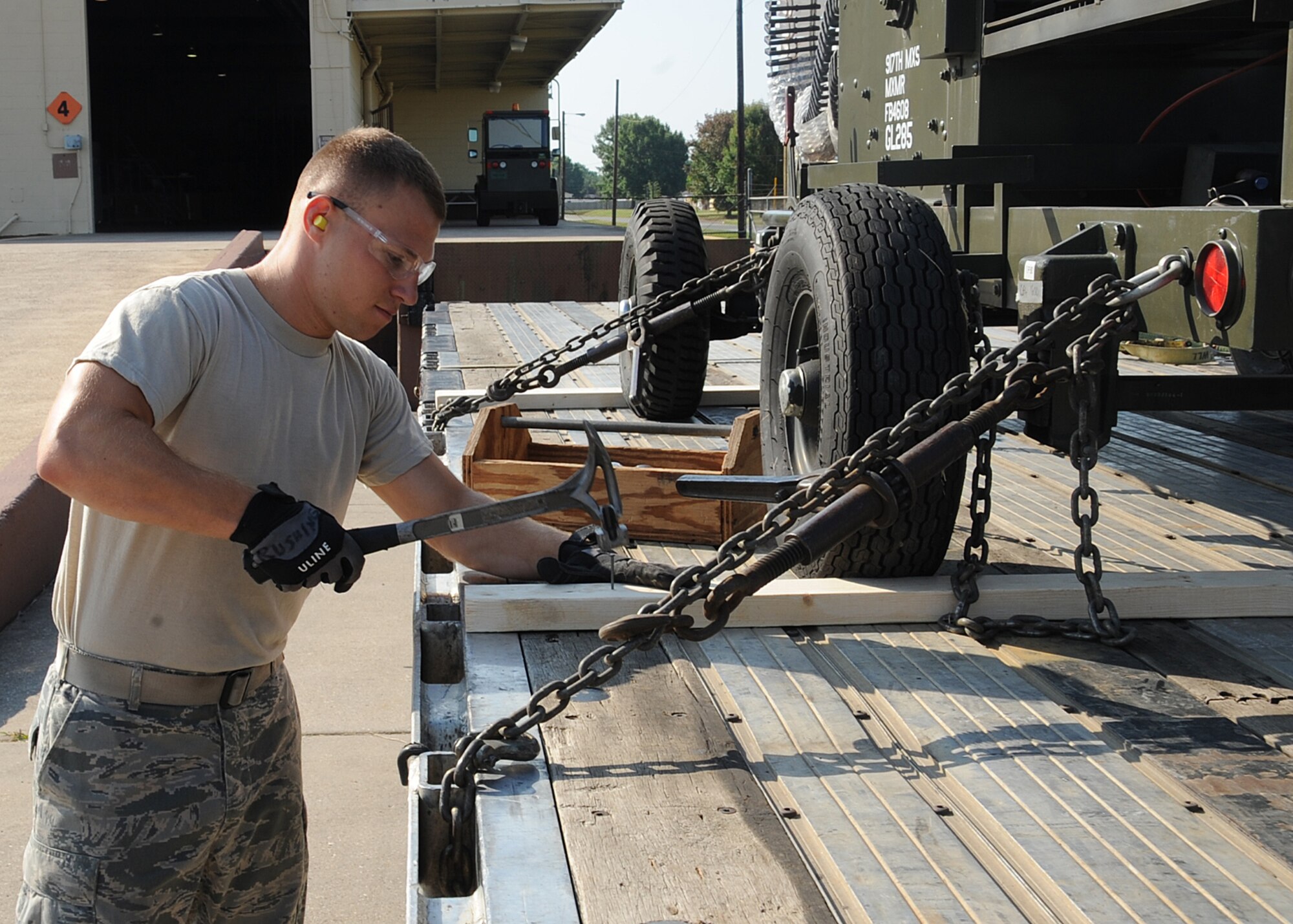Airman 1st Class Justin Rushing, 2nd Logistics Readiness Squadron shipment distribution center apprentice, secures a piece of cargo for shipment on Barksdale Air Force Base, La., July 25, 2013. The shipment distribution center compares several modes of transportation and chooses the most cost effective. (U.S. Air Force photo/Senior Airman Sean Martin)

