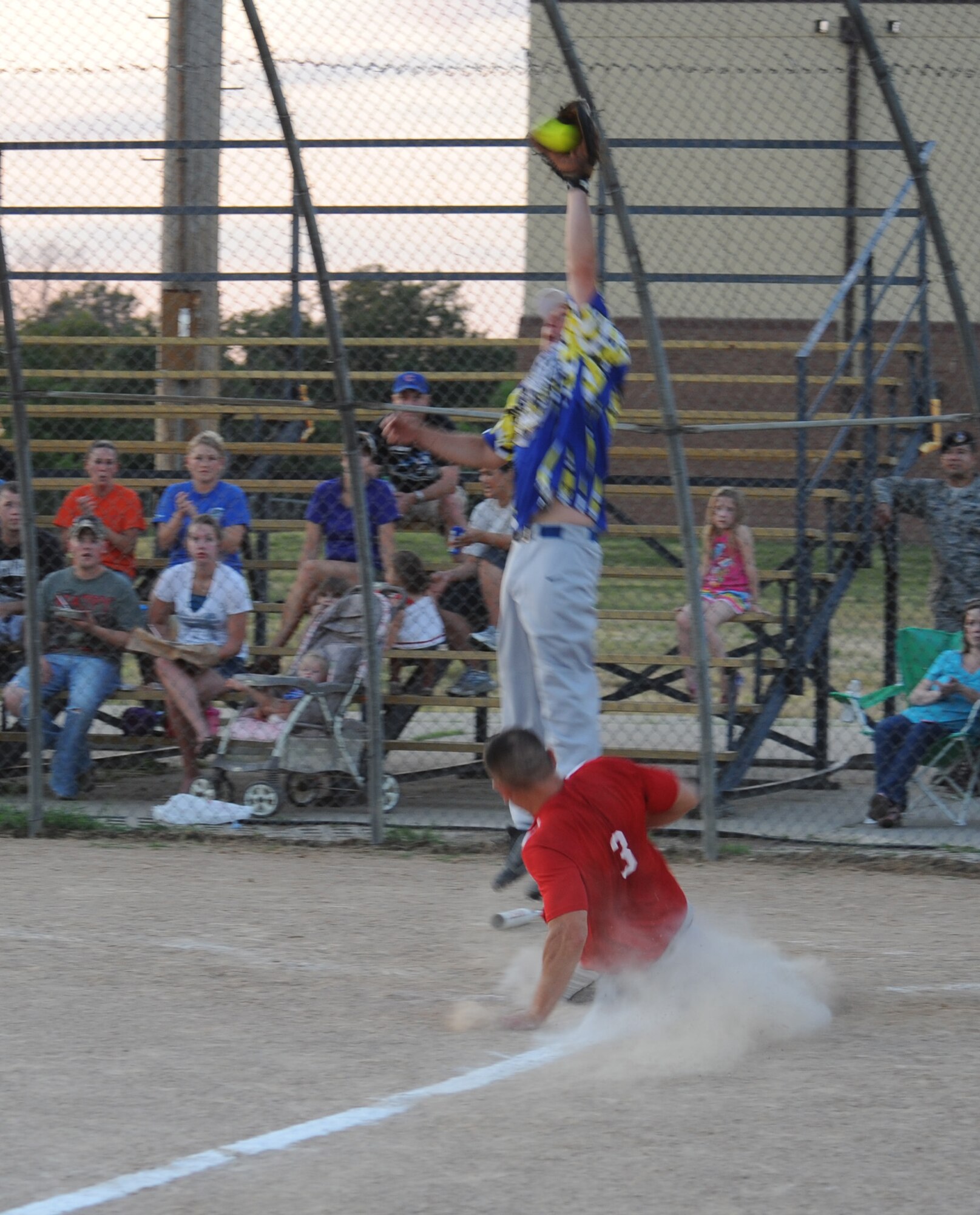 Jake Davis, Security Forces-A catcher, catches a ball at home plate as Matthew Mattes, Civil Engineering outfielder, slides in safely at home plate, at Whiteman Air Force Base, Mo., July 22, 2013. With the win, CE took first place in the Whiteman Intramural Softball League. (U.S. Air Force photo by Airman 1st Class Bryan Crane/Released)