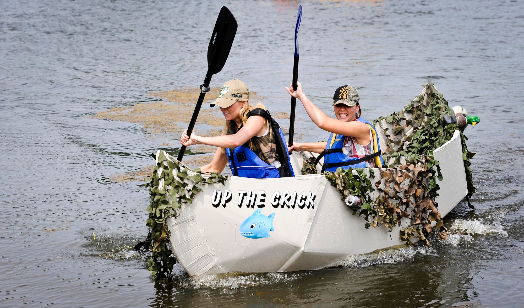 Second Lt. Tahlia Smoke 305th Maintenance Squadron maintenance flight commander, and Senior Airman Chelsie Rodeheaver 305th MXS metals technology journeyman, race to the finish line during the second annual Cardboard Boat Regatta at Willow Pond July 20, 2013, at Joint Base McGuire-Dix-Lakehurst, N.J. (U.S. Air Force photo by Airman 1st Class Ryan Throneberry/Released)