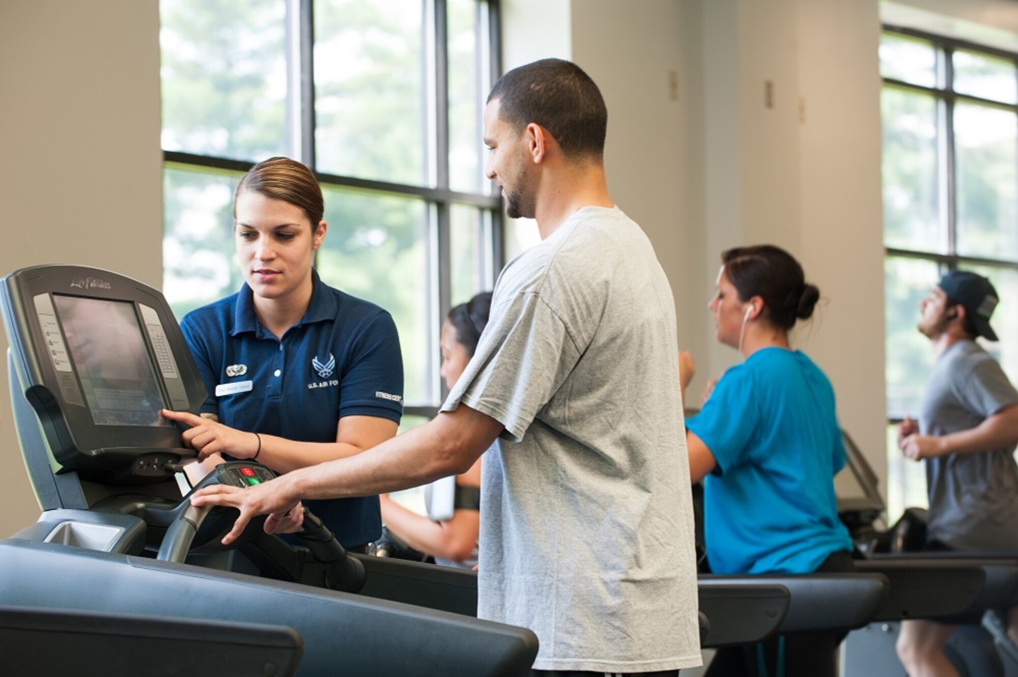 Staff Sgt. Amanda Fallwell, 87th Force Support Squadron fitness specialists, instructs Ramy Lawandy, 87th Civil Engineer Squadron project manager, on how to program the treadmill workout computer July 17, 2013, at the McGuire Fitness Center on Joint Base McGuire-Dix-Lakehurst, N.J. The fitness center offers aerobic classes, work out plans, intramural sports programs and base-wide physical training testing. Fallwell hails from Taunton, Mass., and Lawandy hails from Bayonne, N.J. (U.S. Air Force photo by Russ Meseroll/Released)