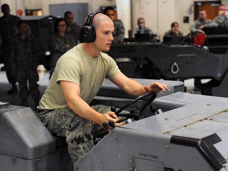 Airman 1st Class Ryan Lose, 393rd Aircraft Maintenance Unit load crew member, uses a jammer to transport a practice munition from a trailer to a mock B-2 Spirit stealth bomber during a load crew competition at Whiteman Air Force Base, Mo., July 18, 2013. Team members with zero deficiencies and the best overall load times are selected to compete in the quarterly competitions. (U.S. Air Force photo by Airman 1st Class Shelby R. Orozco/Released)