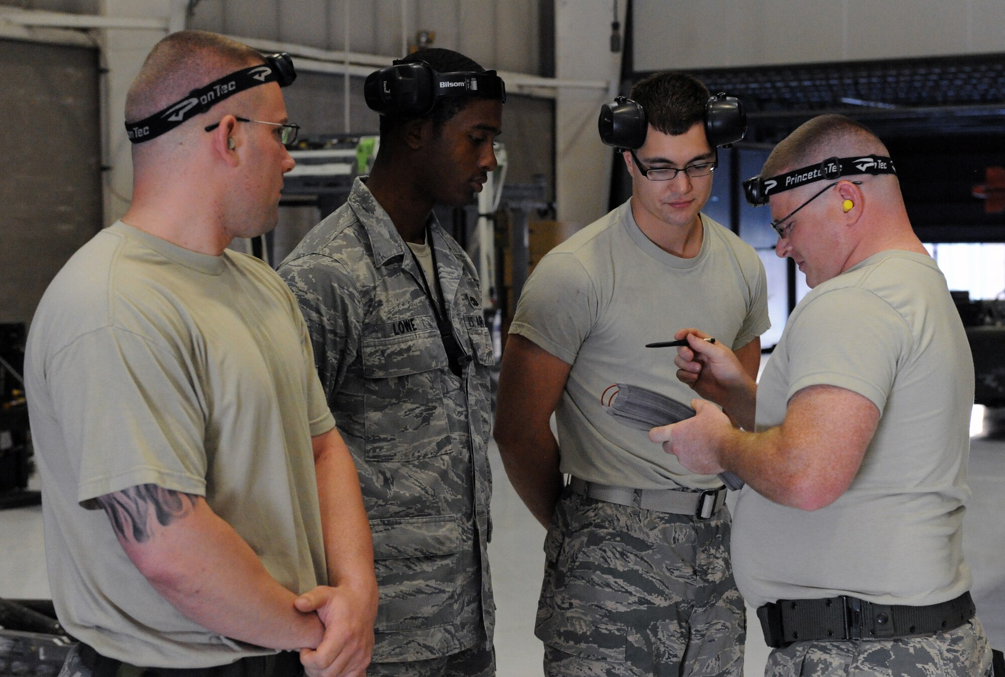 Staff Sgt. Chad Gallant, Senior Airman Keandre Lowe and Airman 1st Class Daniel Rexius listen to their team chief, Staff Sgt. Floyd Brooks, explain their plan of attack during a load crew of the quarter competition at Whiteman Air Force Base, Mo., July 18, 2013. All four Airmen are from the 13th Aircraft Maintenance Unit. (U.S. Air Force photo by Airman 1st Class Shelby R. Orozco/Released)