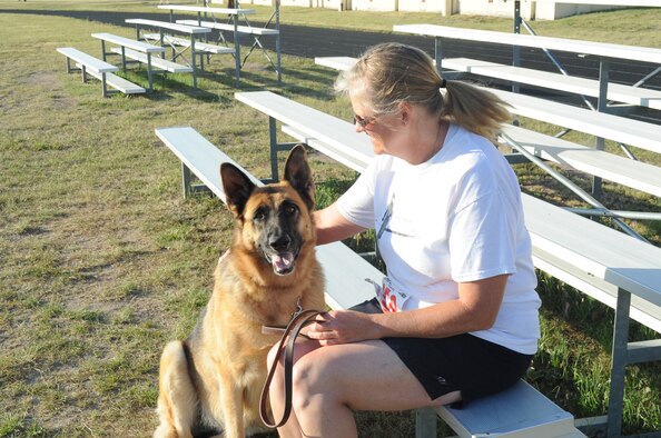 Val Kraenzel, 341st Medical Operations Squadron dental technician, relaxes with her dog, Whisky, before the start of the 2K, Dog ‘N’ Jog event during the Second Annual Striker Life Half Marathon at the Fitness Center on July 20. Kraenzel’s dog Whisky is a 5-year-old German shepherd (U.S. Air Force photo/Airman 1st Class Collin Schmidt)


