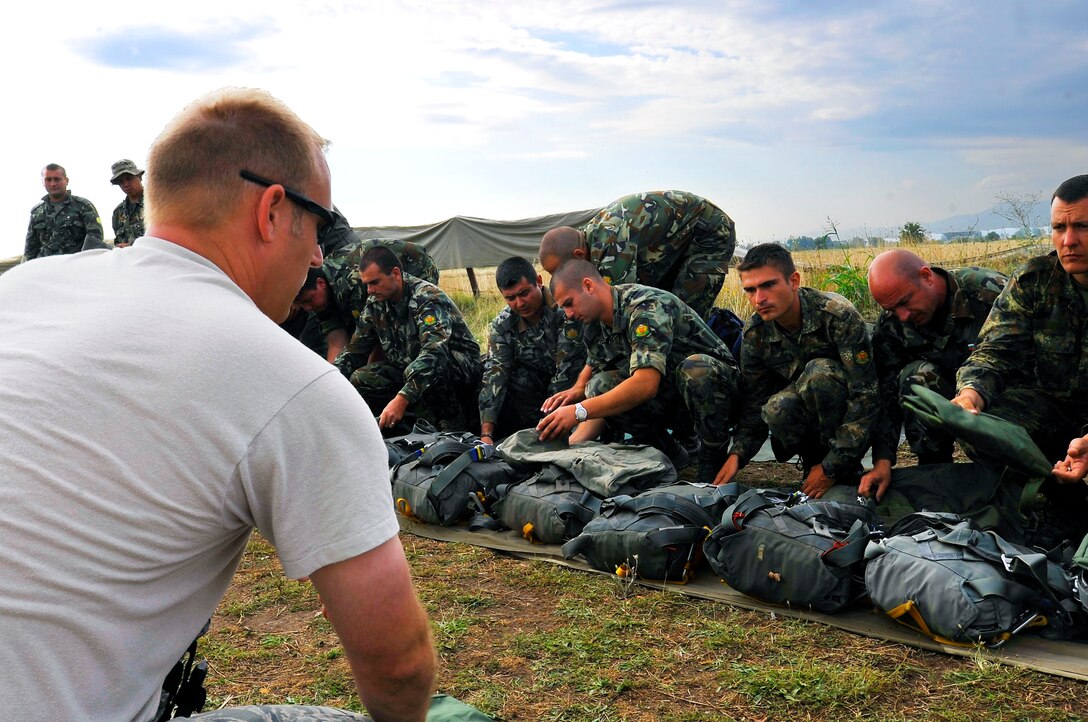 Master Sgt. Stephen Nelson, 435th Contingency Response Group contingency air traffic controller, instructs Bulgarian paratroopers on the correct way to use a standard U.S. parachute during a flying training deployment, July 17, 2013, Plovdiv, Bulgaria. American and Bulgarian paratroopers exchanged parachutes for the opportunity to conduct a wing exchange at the end of FTD Thracian Summer. (U.S. Air Force photo/Airman 1st Class Trevor Rhynes)