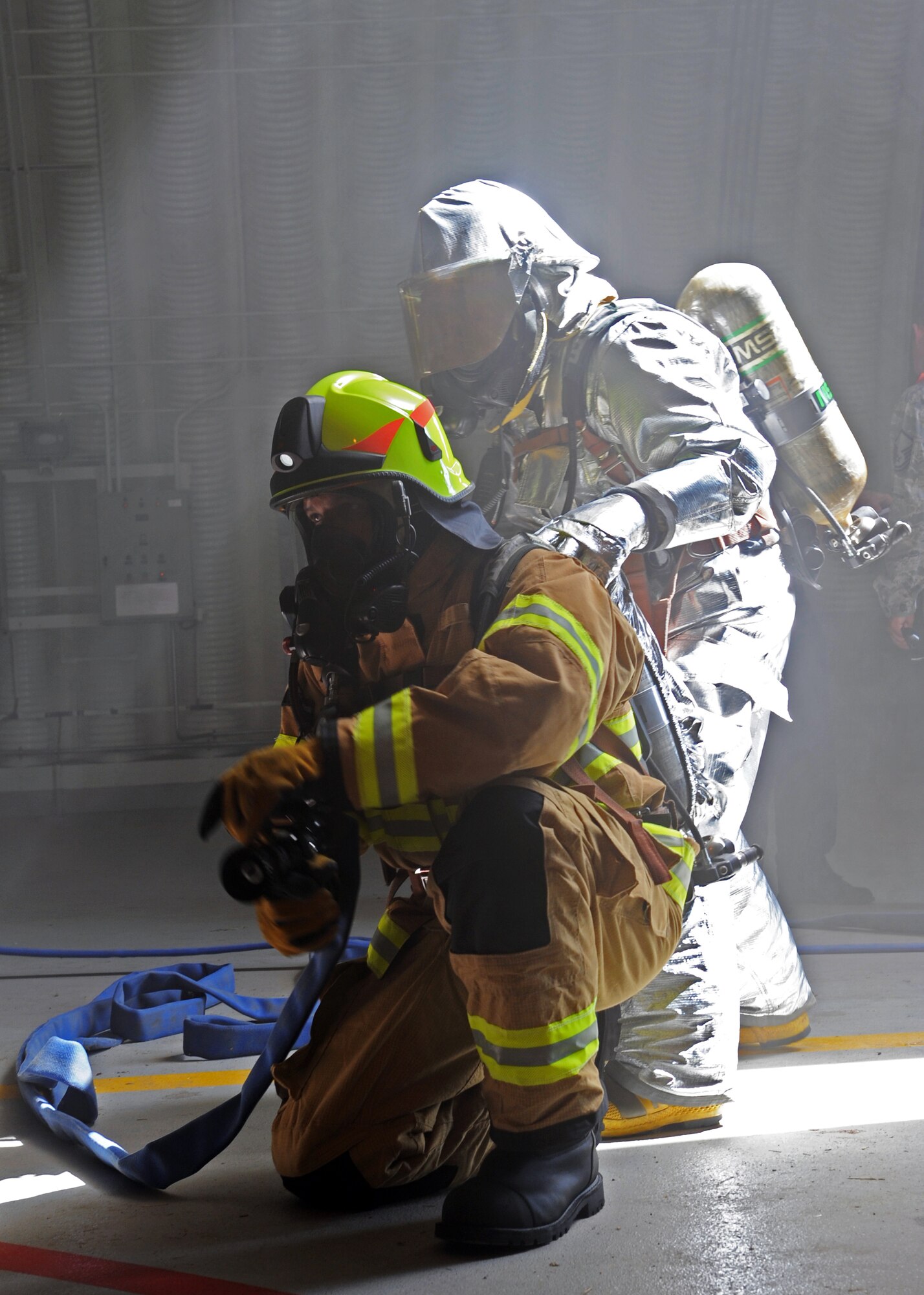 Emil Onentasei, 39th Civil Engineer Squadron firefighter crew chief, and Hakan Erdal, 39th CES firefighter, simulate extinguishing a fire during an exercise July 24, 2013, at Incirlik Air Base, Turkey. Wing-wide exercises can test any Airman’s abilities to respond to any unexpected incident. (U.S. Air Force photo by Senior Airman Chase Hedrick/Released)