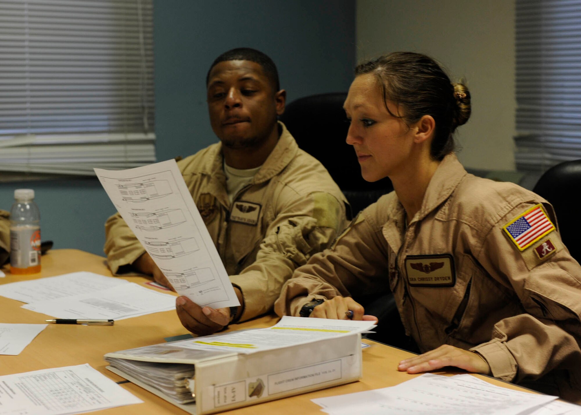 Tech. Sgt. Travis Adams and Senior Airman Chrissy Dryden review mission information in preparation for an aeromedical evacuation mission at the 379th Air Expeditionary Wing in Southwest Asia, July 24, 2013. The 379th Expeditionary Aeromedical Evacuation Squadron Aeromedical Evacuation Operations Team provides medical flight crew members with patient and location information prior to AE missions. Adams and Dryden are 379th EAES aeromedical evacuation technicians deployed from Pope Army Airfield, N.C. and Maxwell Air Force Base, Ala., respectively. (U.S. Air Force photo/Senior Airman Bahja J. Jones) 