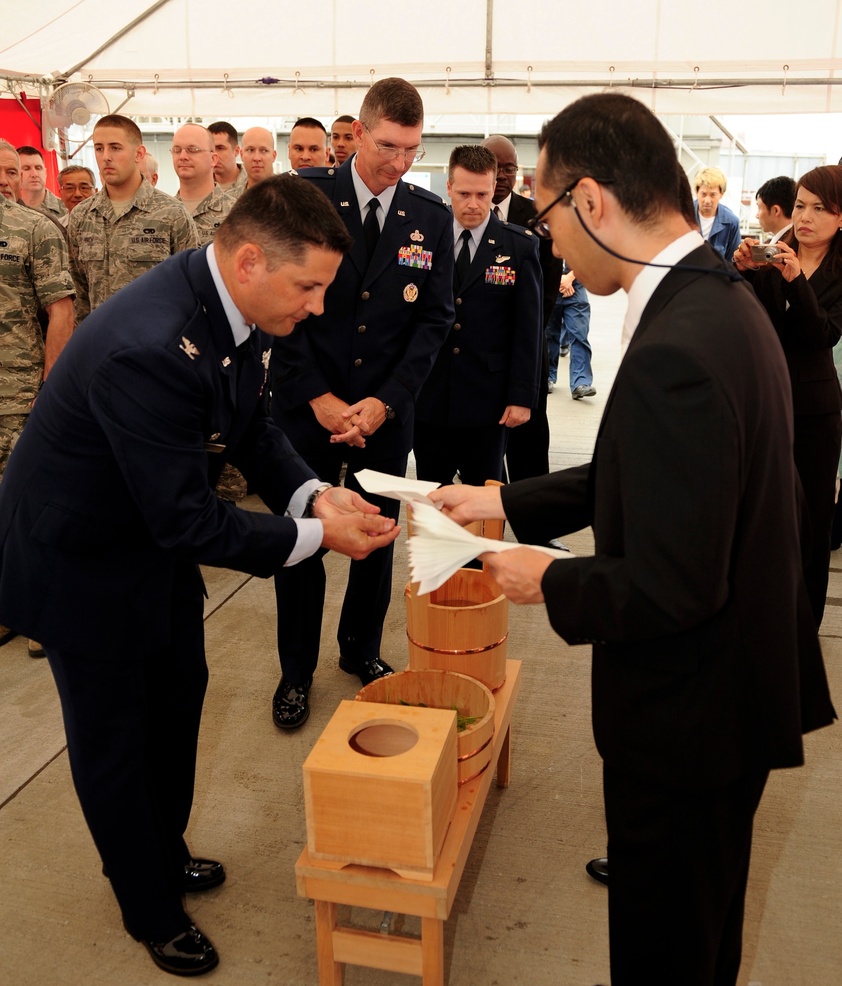 Col. Kenneth Brownell, 515th Air Mobility Operations Group commander; Col. Edward Brown, 374th Medical Group commander; and Lt. Col. Brett Sowell, 730th Air Mobility Squadron commander, stand in a line and rinse their hands before the 730 AMS’ new Mechanized Materials Handling System building ground breaking ceremony at Yokota Air Base, Japan, July 24, 2013. Along with being able to store more pallets, the new MMHS will reduce the amount of time is takes to sequence a cargo load by 75 percent. (U.S. Air Force photo by Senior Airman Michael Washburn)