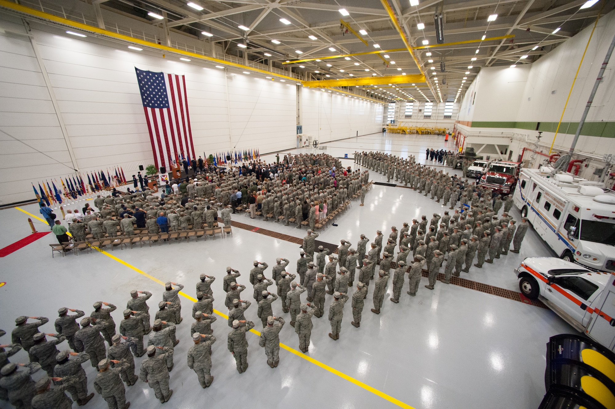 Members of the 87th Air Base Wing stand in formation and salute during the National Anthem at the Joint Base McGuire-Dix-Lakehurst and 87th ABW Change of Command ceremony, July 25, 2013 in the VR-64 Hangar at the joint base.  Col. James C. Hodges assumed command from Col. John Wood during the ceremony. (U.S. Air Force photo by Wayne Russell/Released)