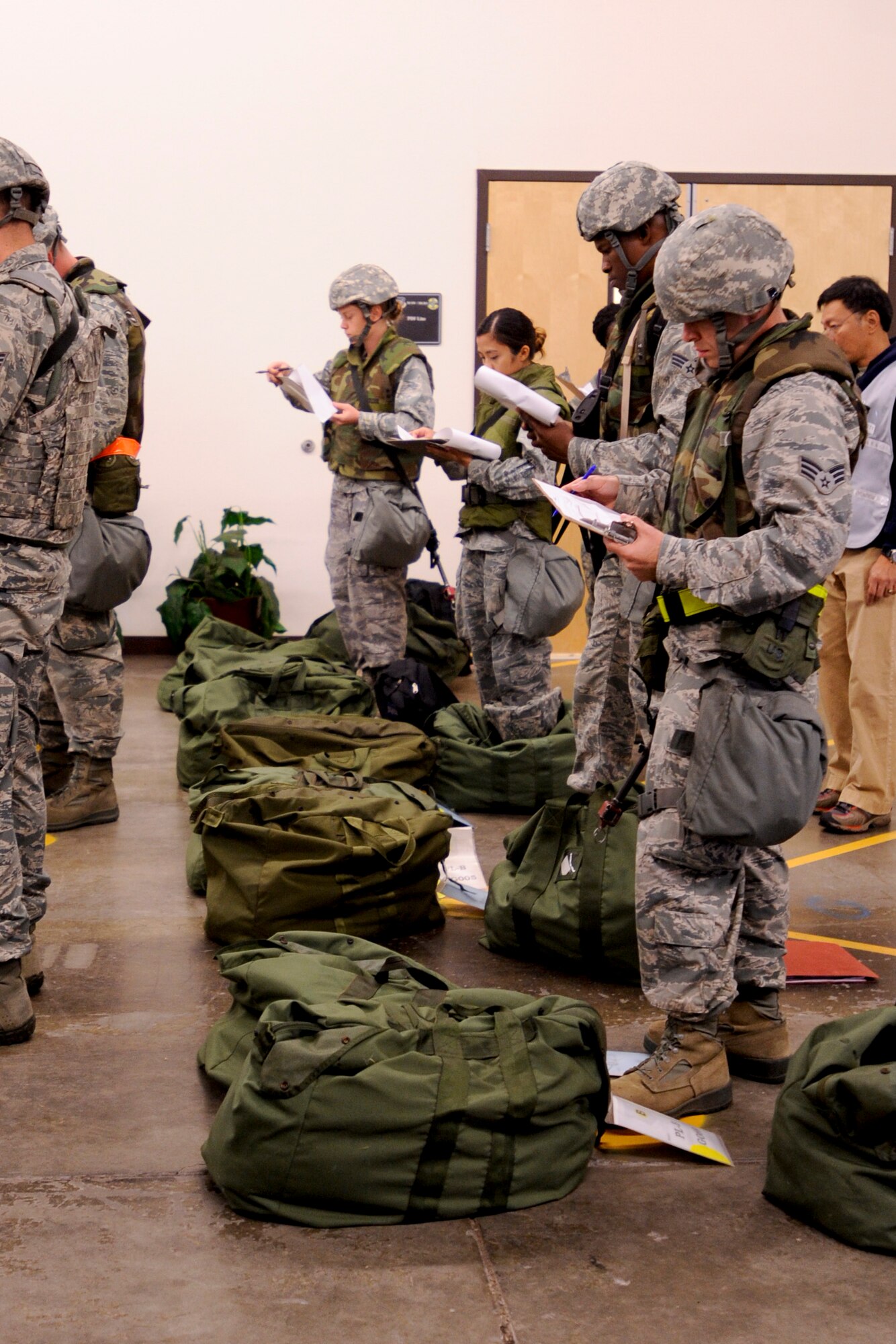 VANDENBERG AIR FORCE BASE, Calif. – Team V members mark their checklist while passing through the Personal Deployment Function line here Thursday, July 25, 2013. The PDF line was held as part of a Consolidated Unit Inspection, a biannual inspection used to measure the base’s discipline, readiness and war fighting capability through exercises, inspection and evaluations. (U.S. Air Force photo/Airman Yvonne Morales)