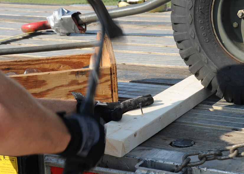 Airman 1st Class Justin Rushing, 2nd Logistics Readiness Squadron shipment distribution center apprentice, secures a piece of cargo for shipment on Barksdale Air Force Base, La., July 25, 2013. The shipment distribution center ships various types of cargo to include hazardous and explosive material in accordance with Department of Defense directives. (U.S. Air Force photo/Senior Airman Sean Martin)