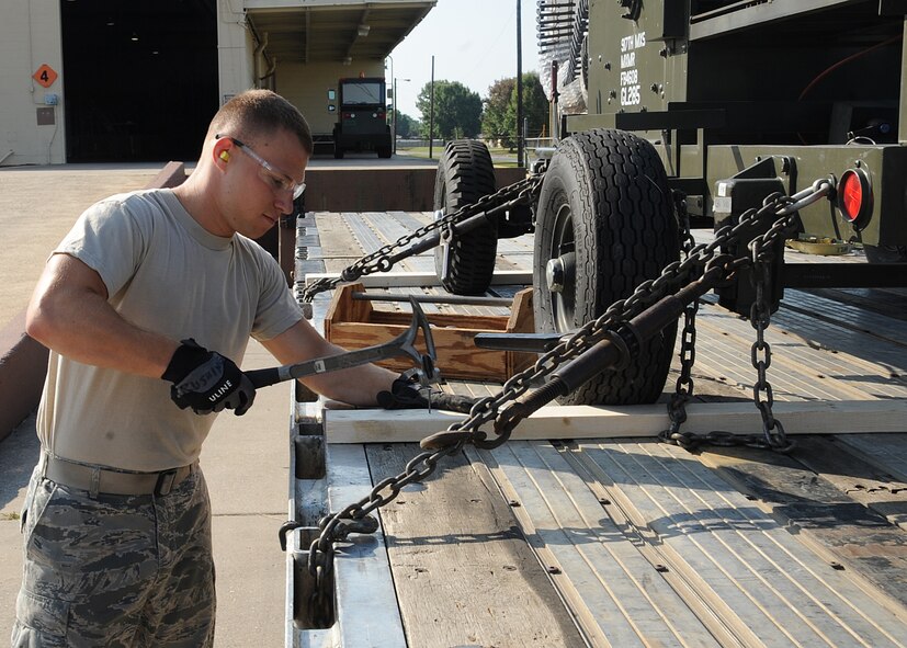 Airman 1st Class Justin Rushing, 2nd Logistics Readiness Squadron shipment distribution center apprentice, secures a piece of cargo for shipment on Barksdale Air Force Base, La., July 25, 2013. The shipment distribution center compares several modes of transportation and chooses the most cost effective. (U.S. Air Force photo/Senior Airman Sean Martin)