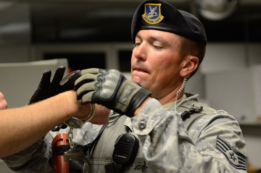 U.S. Air Force Staff Sgt. Craig Windmeyer with the 139th Security Forces Squadron, Missouri Air National Guard, removes handcuffs from a roll-player during an active shooter exercise at Rosecrans Air National Guard Base, Mo., July 25, 2013.  Active shooter exercises allow security forces Airmen the opportunity to prepare for a potential shooter on the base.  (U.S. Air National Guard photo by Tech. Sgt. Theo Ramsey/Released)