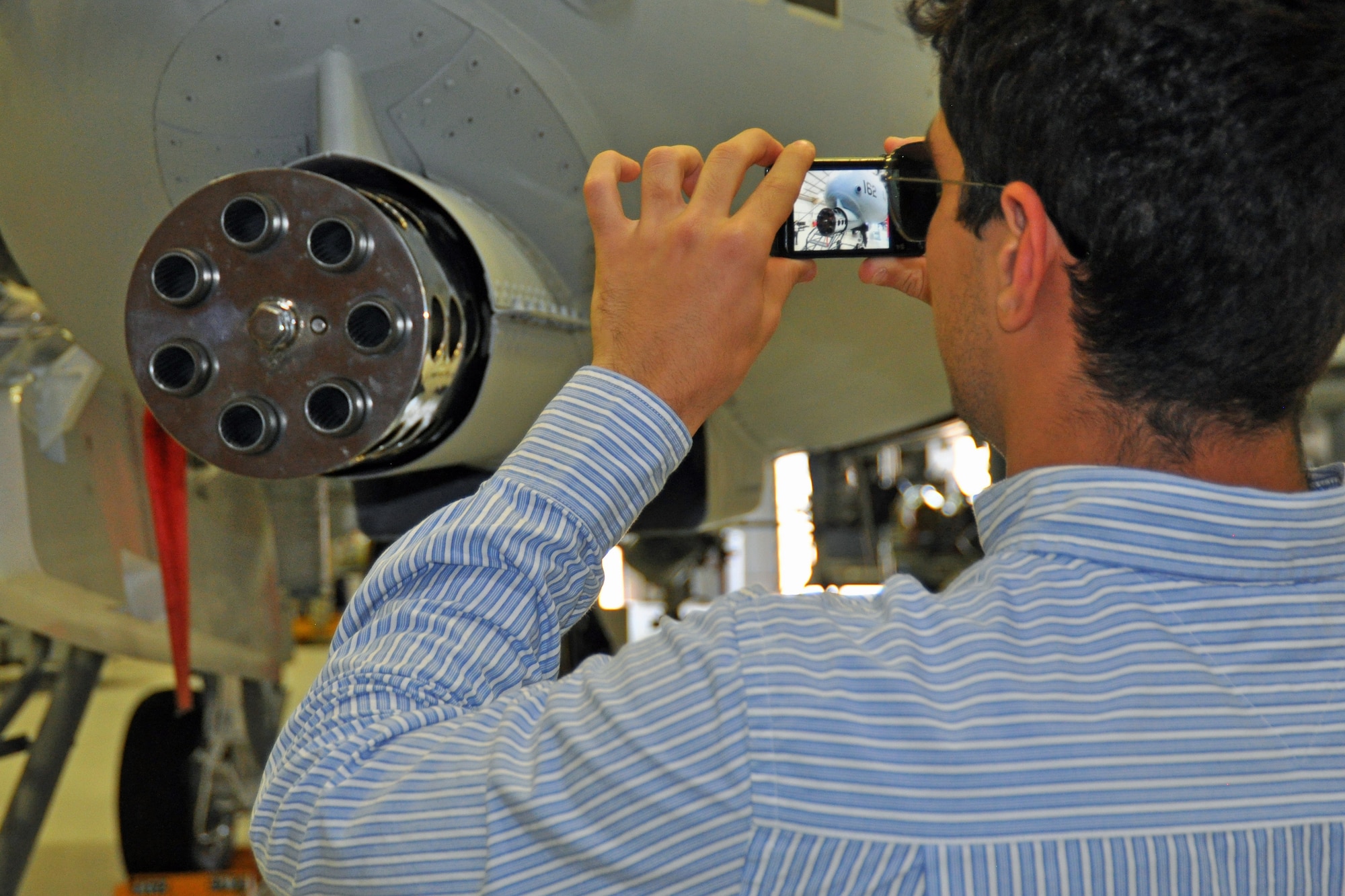 A Brazilian engineering student snaps a picture of the U.S. Air Force A-10 Thunderbolt II’s GAU-8/A 30mm cannon, capable of firing 3,900 rounds per minute, at Davis-Monthan Air Force Base, July 24. The students were in Tucson, Ariz., visiting the nearby Raytheon Company as part of Brazil’s Science Without Borders program and requested the opportunity to visit D-M.  The A-10 is a close air support aircraft that has proven invaluable to the United States and its allies in operations including Desert Storm, Southern Watch, Provide Comfort, Desert Fox, Noble Anvil, Deny Flight, Deliberate Guard, Allied Force, Enduring Freedom and Iraqi Freedom. (U.S. Air Force photo/Capt. Jonathan Simmons)