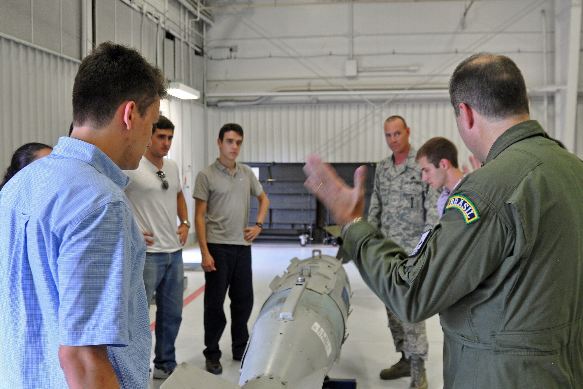 Col. Paulo Vasconcellos, Brazilian Air Force liaison officer to Headquarters Twelfth Air Force (Air Forces Southern), discusses the Joint Direct Attack Munition GBU-31 bomb with graduate and doctoral engineering students from Brazil during a visit to Davis-Monthan Air Force Base, July 24. The students were in Tucson, Ariz., visiting the nearby Raytheon Company as part of Brazil’s Science Without Borders program and requested the opportunity to visit D-M.  The GBU-31 is the largest version of the JDAM weighing in at approximately 2,000 pounds. (U.S. Air Force photo/Capt. Jonathan Simmons)