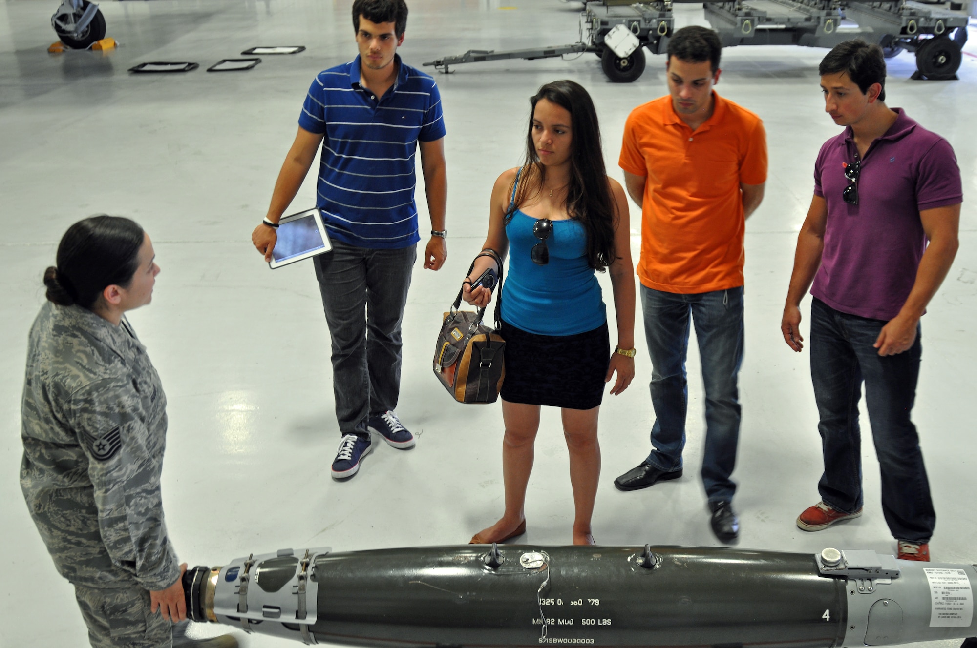 Graduate and doctoral engineering students from Brazil discuss the Joint Direct Attack Munition GBU-38 bomb with Tech. Sgt. Loraine Goody, a load standardization crew member assigned to the 355th Maintenance Operations Squadron, at Davis-Monthan Air Force Base, July 24. The students were in Tucson, Ariz., visiting the nearby Raytheon Company as part of Brazil’s Science Without Borders program and requested the opportunity to visit D-M.  The GBU-38 is the smallest version of the JDAM weighing in at approximately 500 pounds. (U.S. Air Force photo/Capt. Jonathan Simmons)