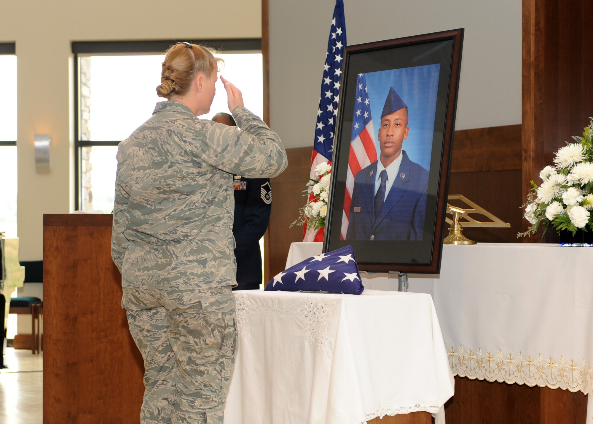 Col. DeAnna Burt, 460th Operations Group commander, renders a final salute to the portrait of Airman 1st Class Shaquille Hargrove July 24, 2013, at the chapel on Buckley Air Force Base, Colo. The chapel was filled to standing-room-only capacity for Hargrove, a 2nd Space Warning Squadron satellite systems operator, who was killed in an incident at 15th and Market Streets in downtown Denver July 13. (U.S. Air Force photo by Senior Airman Marcy Glass/Released)