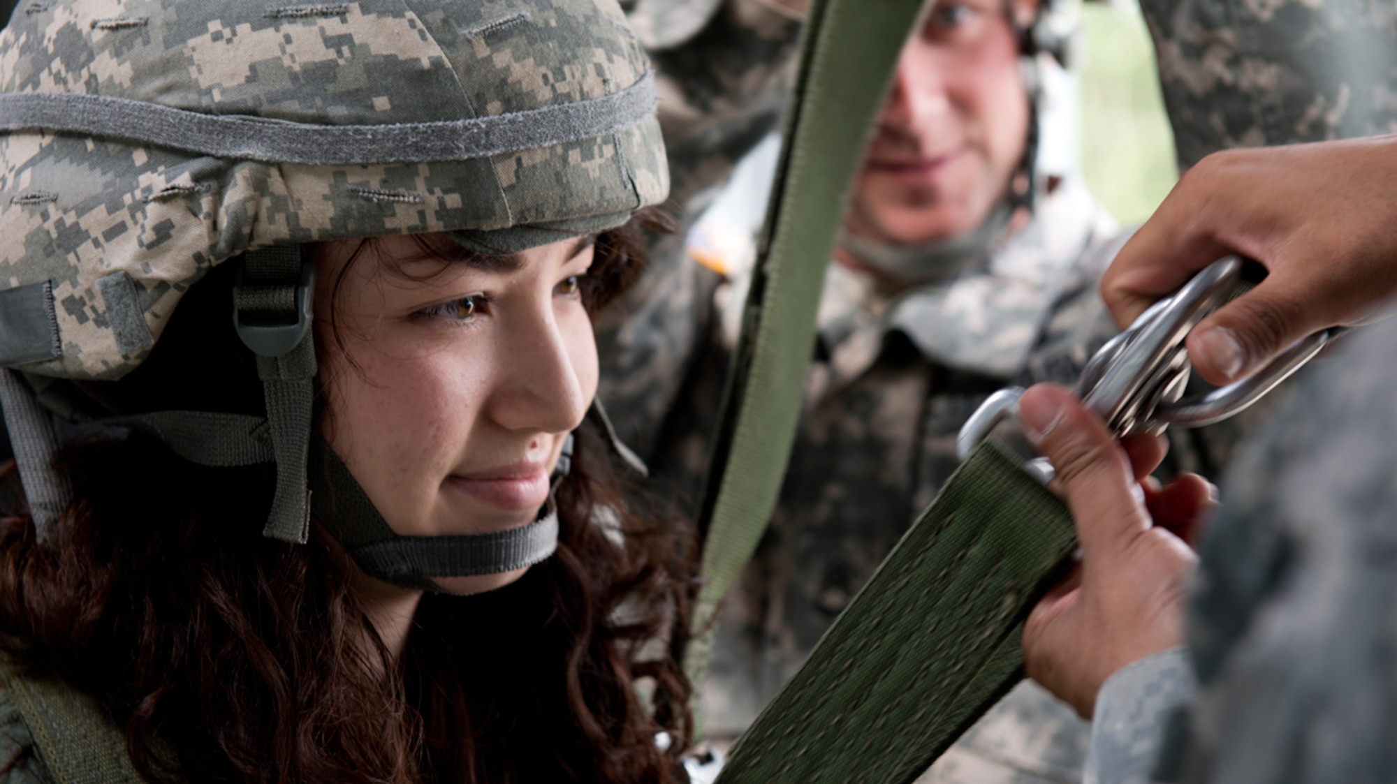 JOINT BASE ELMENDORF-RICHARDSON, Alaska -- Michelle Shablesky, spouse of Army 2LT Mitchell Shablesky, watches closely as two airborne jumpmasters inspect her harness before her 34-foot jump off of hte Airborne Sustainment Training Tower during the 2nd Battalion, 377th Parachute Field Artillery Regiment G.I. Jane day.  The event is designed to show spouses what a day in the life of their Soldier is like, and to support family and unit bonding. (U.S. Air Force Photo/Airman 1st Class Austin Willhoit)