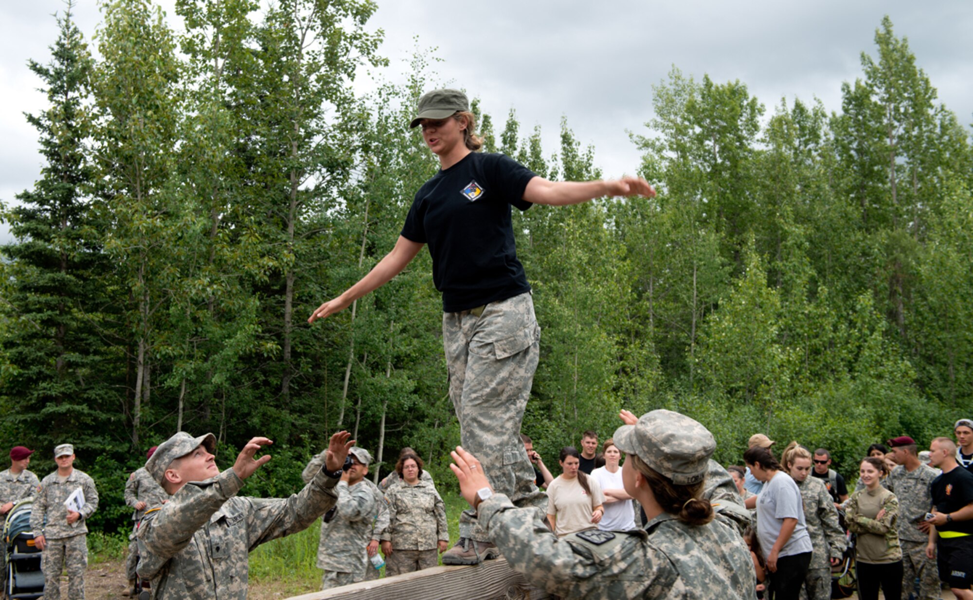 JOINT BASE ELMENDORF-RICHARDSON, Alaska -- Jenna Caldwell, spouse of Army SSG Justin Caldwell, navigates a wood plank at the Joint Base Elmendorf-Richardson obstacle course during the 2nd Battalion, 377th Parachute Field Artillery Regiment G.I. Jane day.  The event is designed to show spouses what a day in the life of their Soldier is like, and to support family and unit bonding. (U.S. Air Force Photo/Airman 1st Class Austin Willhoit)