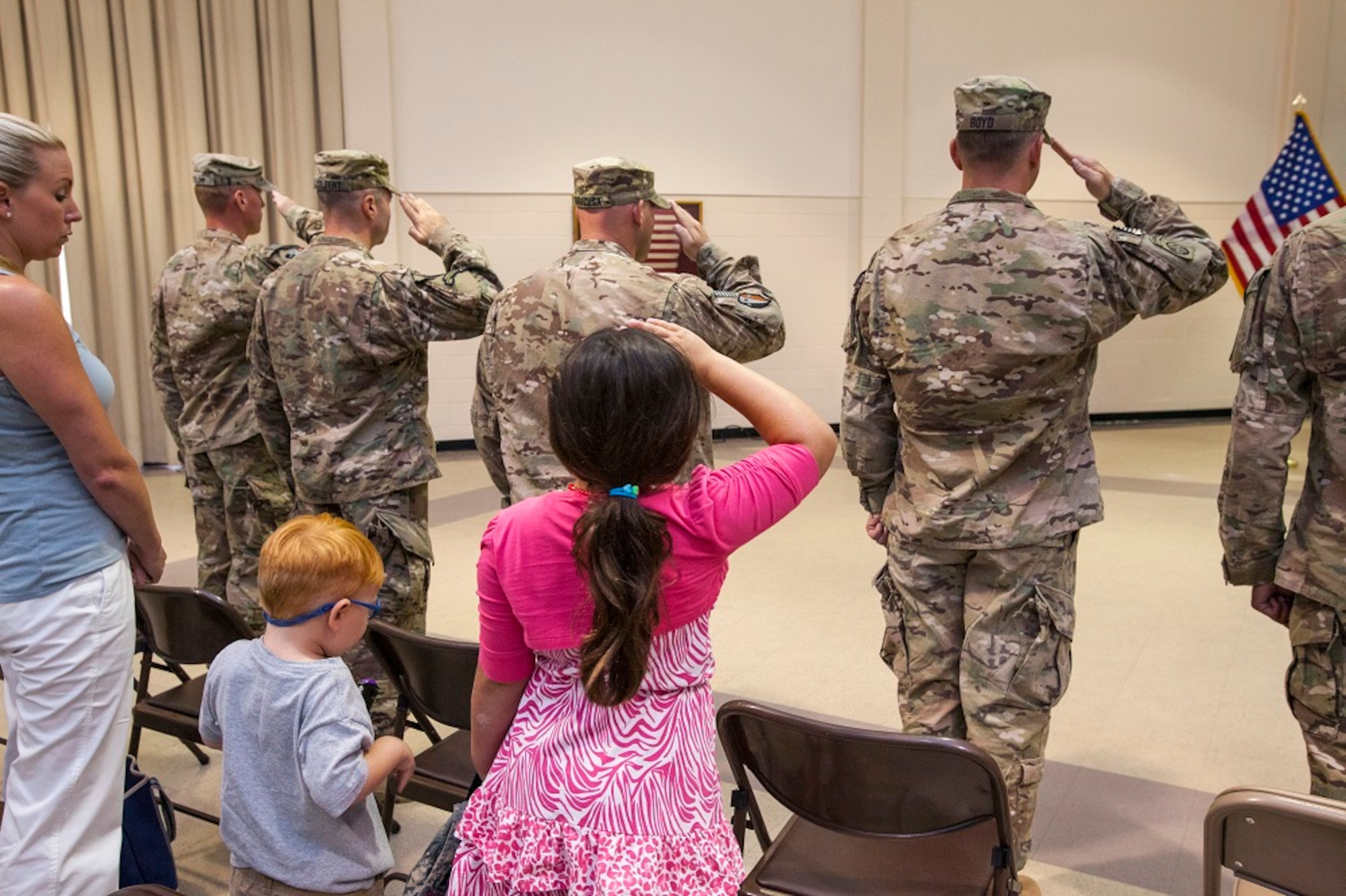 Sienna Nichole Siracusa, daughter of Maj. Vincent Siracusa Jr., follows her father's example and salutes during the national anthem during the welcome home ceremony for the Military Advisor Team III who returned after a year-long deployment in support of Operation Enduring Freedom in Afghanistan July 22, 2013, to Joint Base McGuire-Dix-Lakehurst, N.J. MATs are small teams of officers and noncommissioned officers whose primary tasks are to coach, teach and mentor Afghan National Army units; provide the conduit for liaison and command and control; and support the operational planning and employment of the ANA. The New Jersey Army National Guard creates joint MATs with the Albanian Armed Forces. The MATs build on state partnership relationships with the Republic of Albania in order to demonstrate commitment and strengthen the alliance with Albania enabling them to contribute to future NATO missions. (U.S. Air Force photo by Master Sgt. Mark C. Olsen/Released)