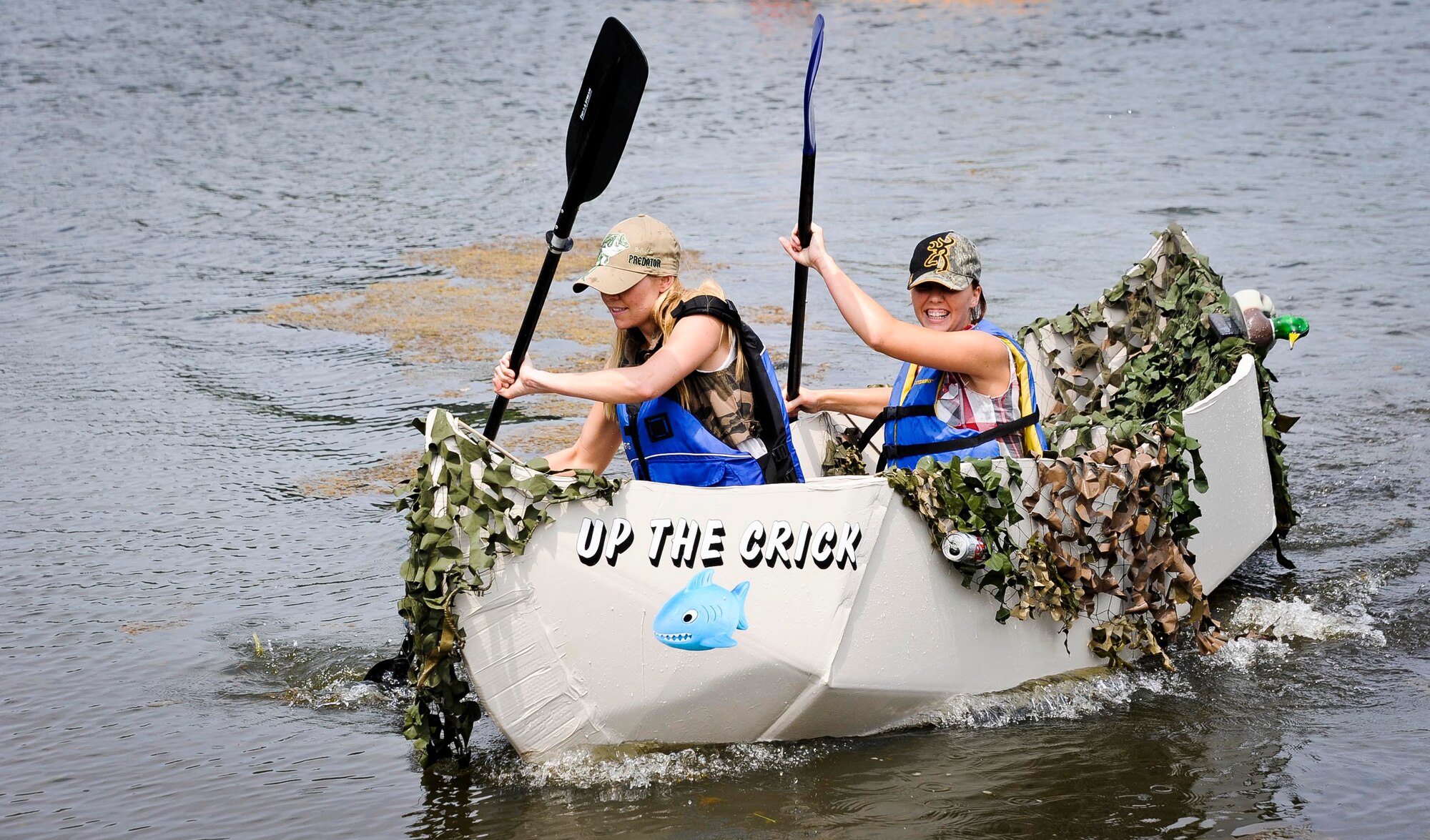 Second Lt. Tahlia Smoke 305th Maintenance Squadron maintenance flight commander, and Senior Airman Chelsie Rodeheaver 305th MXS metals technology journeyman, race to the finish line during the second annual Cardboard Boat Regatta at Willow Pond July 20, 2013, at Joint Base McGuire-Dix-Lakehurst, N.J. (U.S. Air Force photo by Airman 1st Class Ryan Throneberry/Released)