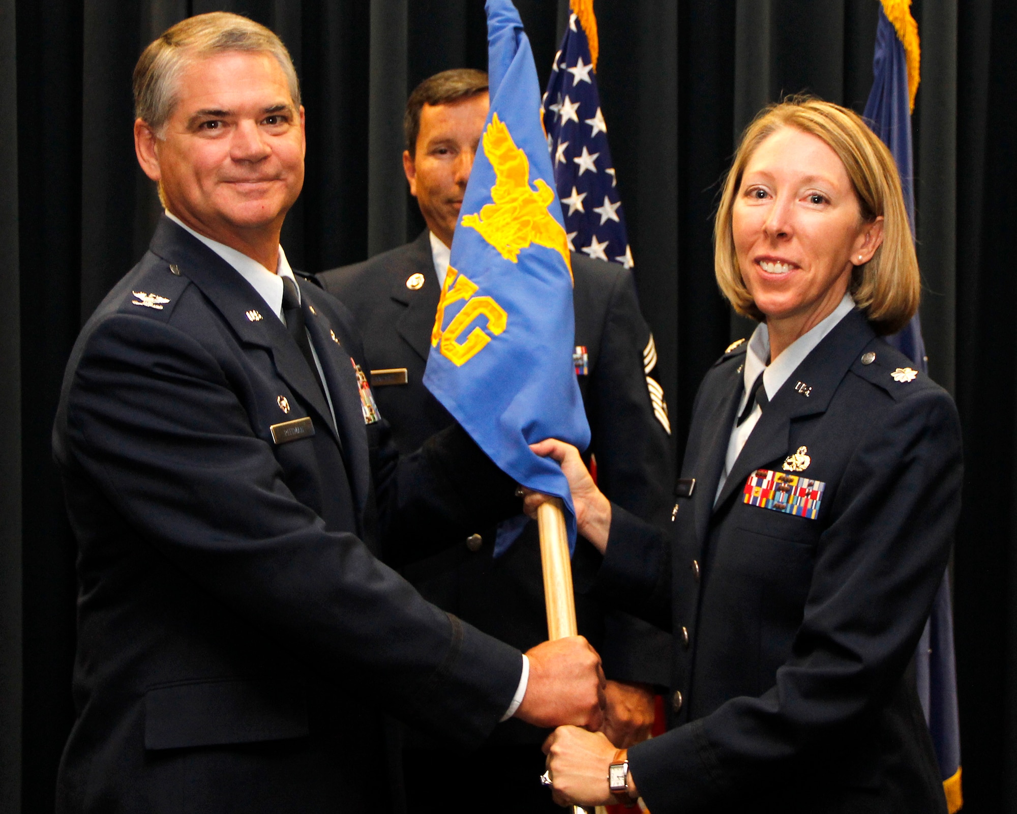 Air Force Reserve Lt. Col. Jennifer Cummings (right) accepts the 302nd Maintenance Group guideon from Col. Jay Pittman, 302nd Airlift Wing commander, during a change of command ceremony July 14 at Peterson Air Force Base, Colo. Cummings was previously the deputy commander of the 302nd MXG. (U.S. Air Force photo/Staff Sgt. Nathan Federico)