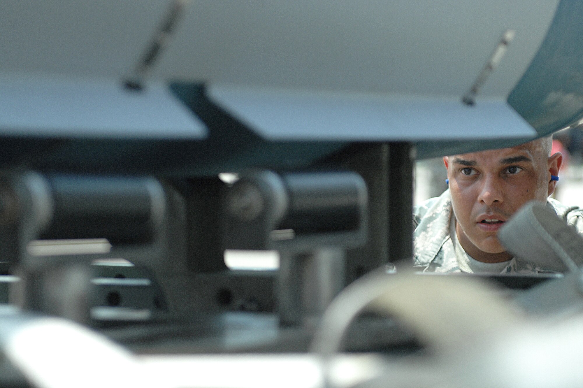 U.S. Air Force Staff Sergeant Daniel Diaz Jr., 4th Aircraft Maintenance Squadron, 333rd Aircraft Maintenance Unit weapons load crew member, watches and directs his teammate as they load a GBU-31 bomb onto a MJ-1 weapons truck during a load crew of the quarter competition at Seymour Johnson Air Force Base, N.C., July 19, 2013.  The MJ-1 weapons truck, also called a jammer, is used to transport and hold munitions in place that are too heavy for crews to hand-carry.  (U.S. Air Force photo by Airman 1st Class Brittain Crolley/Released)