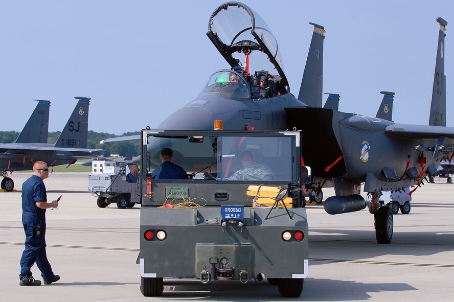 Airmen assigned to the 4th Aircraft Maintenance Squadron, 334th Aircraft Maintenance Unit, direct and maneuver an F-15E Strike Eagle into position during a load crew of the quarter competition at Seymour Johnson Air Force Base, N.C., July 19, 2013.  Each of the four crews was graded on how quickly and accurately they could tow the aircraft into a defined area.  (U.S. Air Force photo by Airman 1st Class Brittain Crolley/Released)
