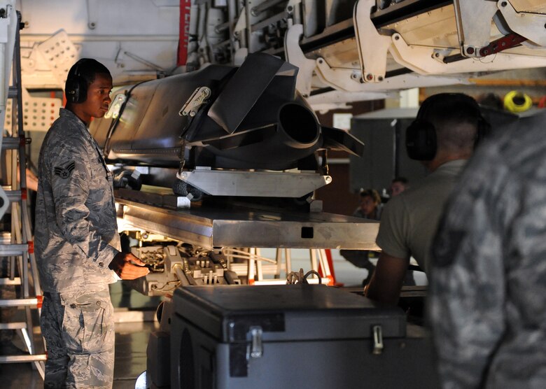 Senior Airman Keandre Lowe guides Airman 1st Class Daniel Rexius, and the practice munition he is transporting, into place during a load crew of the quarter competition at Whiteman Air Force Base, Mo., July 18, 2013. The load crew competition uses practice munitions and a mock B-2 Spirit stealth bomber to simulate real-world loading conditions. Both Airmen are load crew team members from the 13th Aircraft Maintenance Unit. (U.S. Air Force photo by Airman 1st Class Shelby R. Orozco/Released)