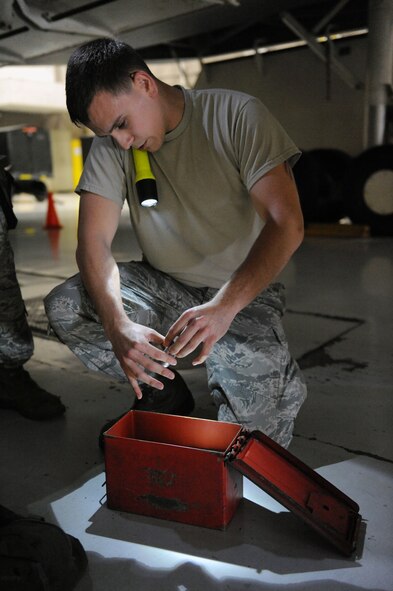 Airman 1st Class Daniel Villarreal, 393rd Aircraft Maintenance Unit load crew member, examines an impulse cartridge during a load crew competition at Whiteman Air Force Base, Mo., July 18, 2013. The Airmen were judged on dress and appearance, toolkit inspections, overall load time and a 25-question test. (U.S. Air Force photo by Airman 1st Class Shelby R. Orozco/Released)