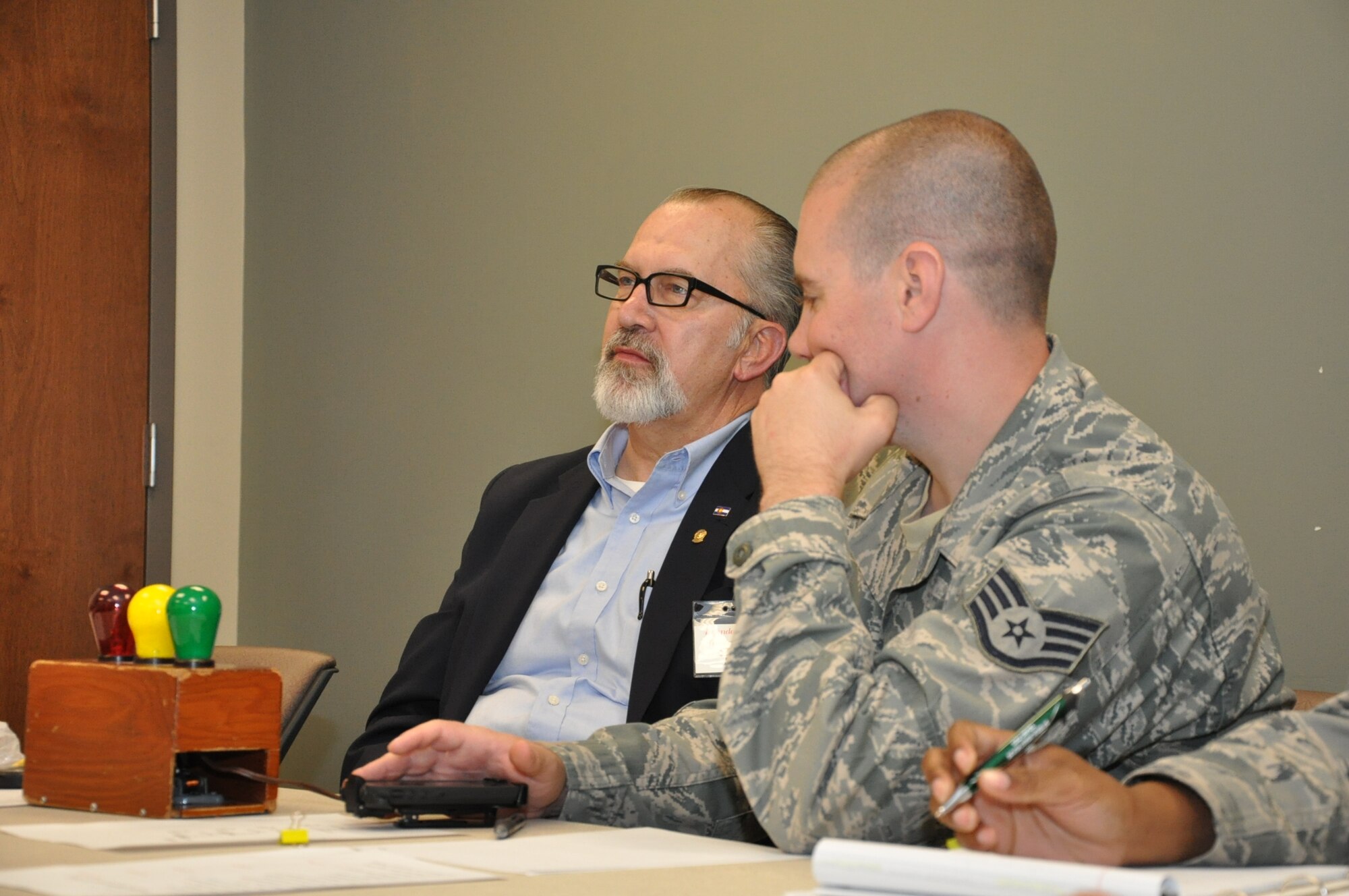 Tom Gross watches a speech given by a fellow club member while Staff Sgt. Kyle Carpenter, club president, monitors the time limit July 10, 2013, at the Buckley Chapel on Buckley Air Force Base, Colo. The Defenders of Speech Toastmasters Club meets bi-monthly at the chapel as a branch of the international group Toastmasters, a volunteer organization dedicated to teaching and developing public presentation and leadership skills. The club is open to anyone with access to base. (U.S. Air Force photo by Master Sgt. Christian Michael)