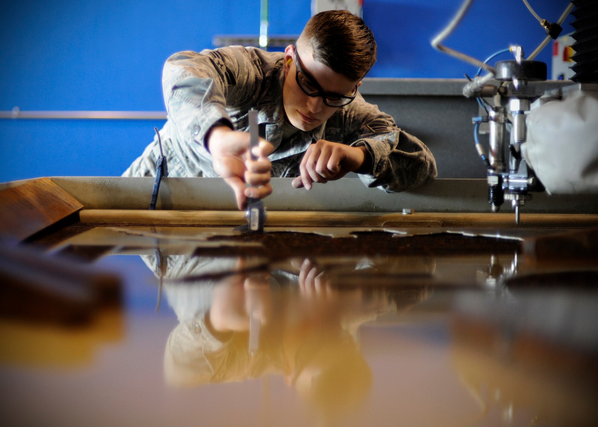 U.S. Air Force Senior Airman Robert Mason, 354th Maintenance Squadron metals technology journeyman, uses a caliper to measure aluminum while fabricating a part for an F-16 Fighting Falcon at Eielson Air Force Base, Alaska, July 22, 2013. Commonly, a part for an aircraft can’t be purchased or is just cheaper to produce. Metals tech Airmen can fabricate almost any part or tool from raw material. (U.S. Air Force Senior Airman Shawn Nickel/Released)