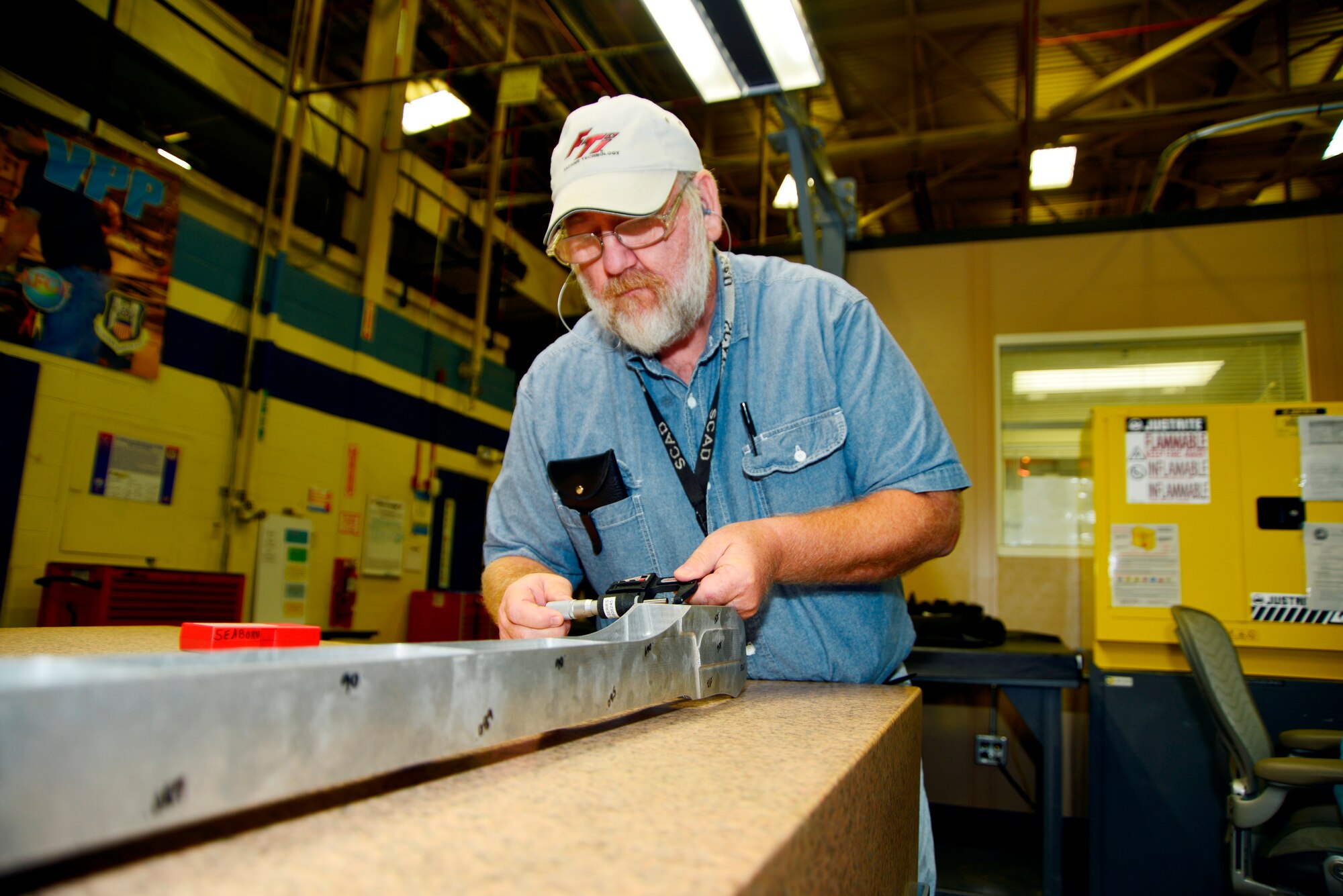 Above, Seaborn Roberts, a machinist on the Makino 5-Axis milling machine, measures the walls of a completed F-15 spar replacement part using a Stamerr digital mircrometer. Below, the milling machine includes a spindle whose speeds are up to 33,000 RPMs. (U.S. Air Force photo by Ed Aspera)