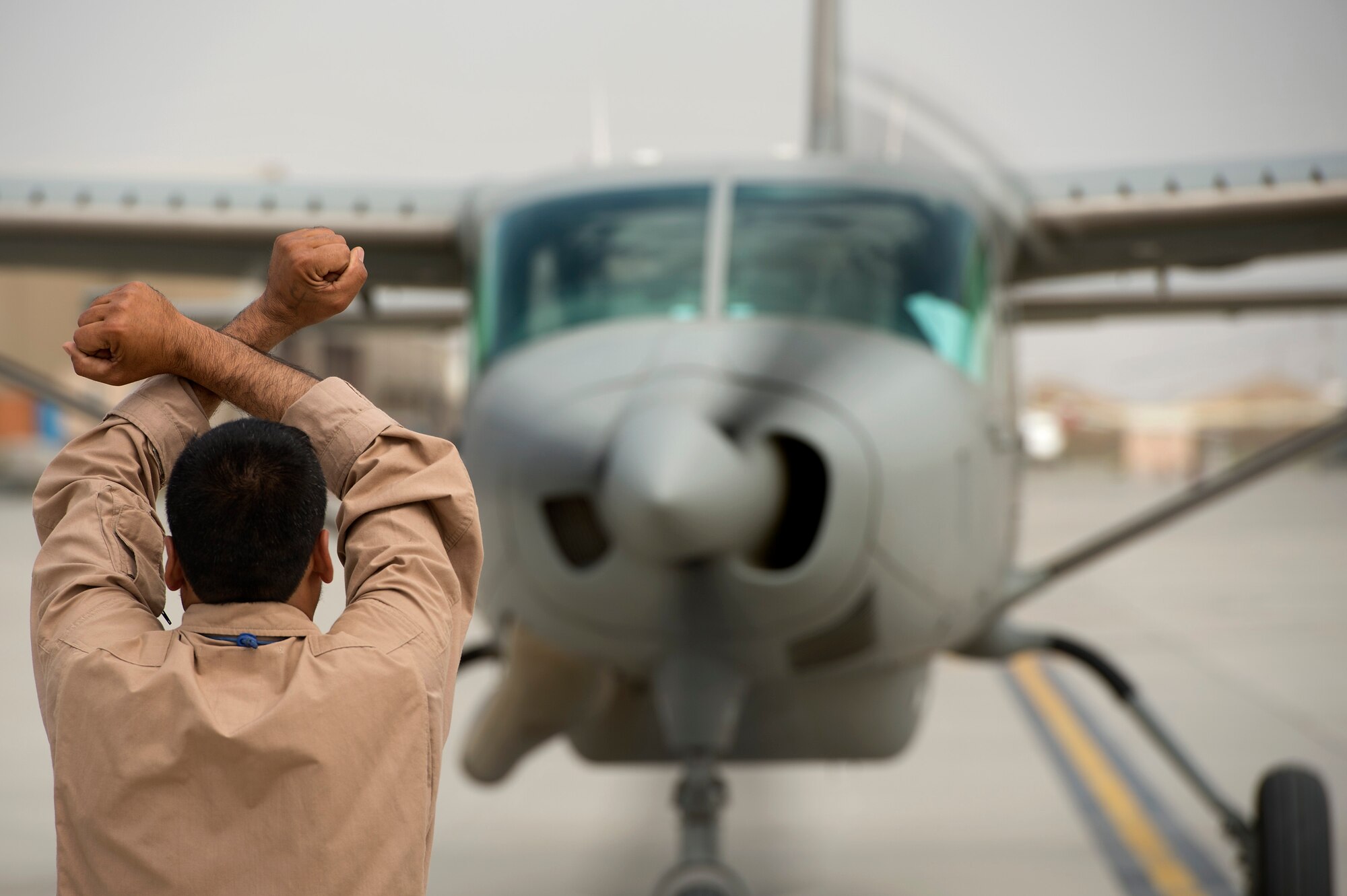 Afghan Air Force Sergeant Jamil, Fixed Wing Squadron crew chief, marshals in a Cessna 208 returning with a patient at Kabul International Airport, Afghanistan, July 13, 2013. Second quarter AAF airlift missions increased more than 50 percent over the first quarter. Casualty evacuation missions alone reached 460 compared to 192 in the first quarter. Maj. Gen.  Abdul Wahab Wardak, Afghan Air Force commander, attributed the growth to an aggressive training program. “[We] have always focused more on training young pilots and young flight engineers so they can perform better in the future for the Afghan Air Force,” said Wahab. (U.S. Air Force Photo/Master Sgt. Ben Bloker)