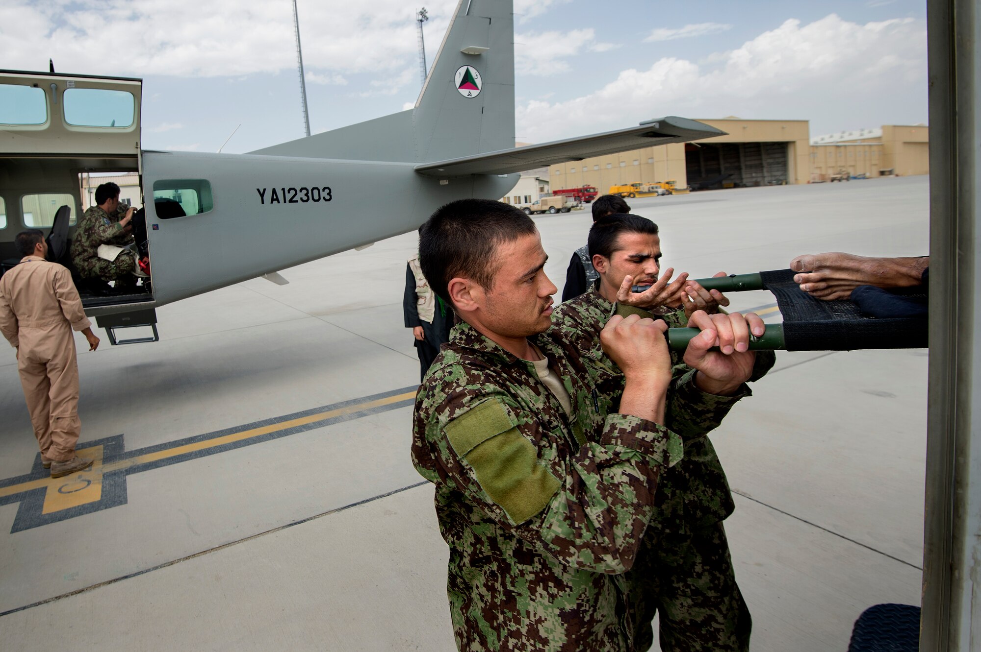 Afghan Air Force soldiers Nasir and Jafar transfer a casualty evacuation patient from a Cessna 208 at Kabul International Airport, Afghanistan, July 13, 2013. Second quarter AAF airlift missions increased more than 50 percent over the first quarter. CASEVAC missions alone reached 460 compared to 192 in the first quarter. Maj. Gen.  Abdul Wahab Wardak, Afghan Air Force commander, attributed the growth to an aggressive training program. “[We] have always focused more on training young pilots and young flight engineers so they can perform better in the future for the Afghan Air Force,” said Wahab. (U.S. Air Force Photo/Master Sgt. Ben Bloker)