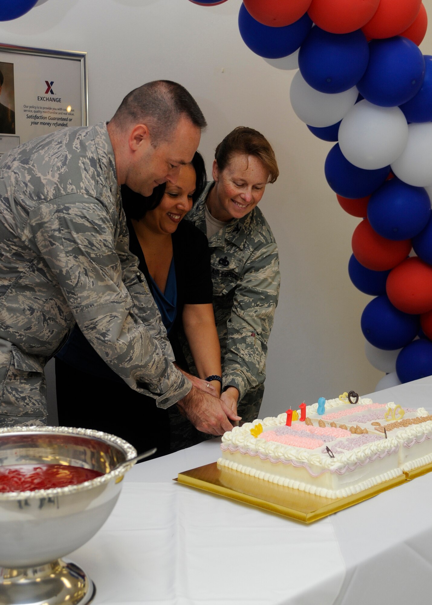 Colonel Timothy Sundvall, 8th Fighter Wing vice commander, Rita Inchaurregul-Powell, Kunsan’s Army and Air Force Exchange Service general manager, and Col. Carrie Bausano, 8th Mission Support Group commander, celebrate AAFES’ 118th birthday by cutting the cake at the Kunsan Air Base, Republic of Korea Base Exchange on July 25, 2013. AAFES celebrated the day with cake, a food-eating contest and discounts for the Wolf Pack. (U.S. Air Force photo by Senior Airman Jessica Haas/Released)