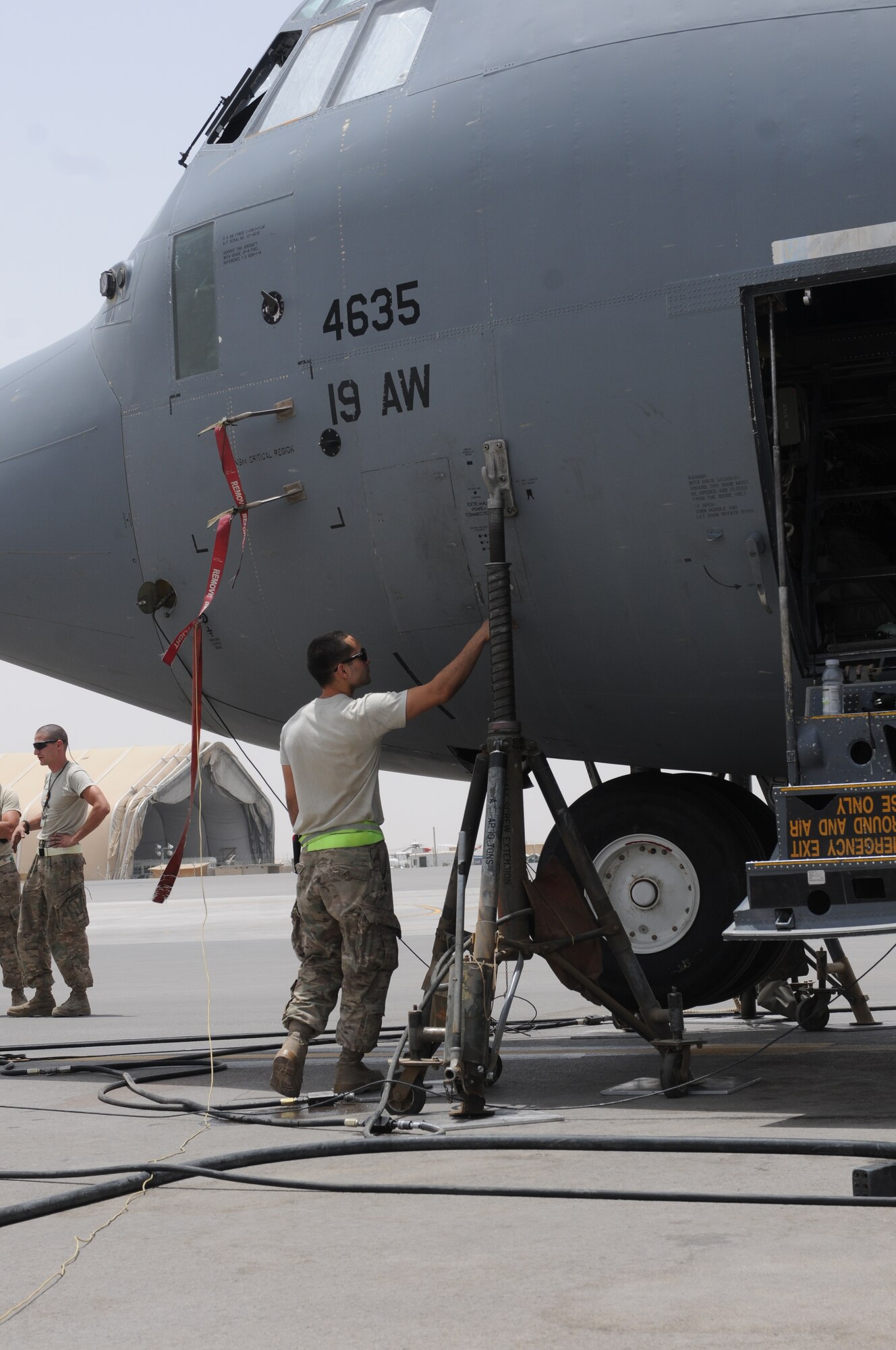 Senior Airman Joseph Cazares closes a port cover on a C-130J Super Hercules after unhooking an external power unit at Kandahar Airfield, Afghanistan, July 17, 2013. The external power unit supplied the power to raise and lower the aircraft’s landing gear while Airmen from the 451st Expeditionary Aircraft Maintenance Squadron worked on a brake line. Cazares is deployed from Little Rock Air Force Base, Ark., and is a native of Long Beach, Calif. (U.S. Air Force photo/Capt. Brian Maguire)