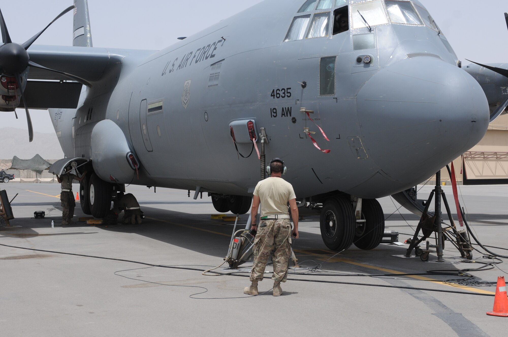Tech. Sgt. Christopher Gordon, 451st Expeditionary Aircraft Maintenance Squadron, waits for Airmen to finish inspecting the brake lines on a C-130J Super Hercules before raising the landing gear at Kandahar Airfield, Afghanistan, July 17, 2013. Airmen raised the C-130J on jacks to easily inspect the brake lines near the landing gear. Gordon is deployed from Little Rock Air Force Base, Ark., and is a native of Hartselle, Ala. (U.S. Air Force photo/Capt. Brian Maguire)