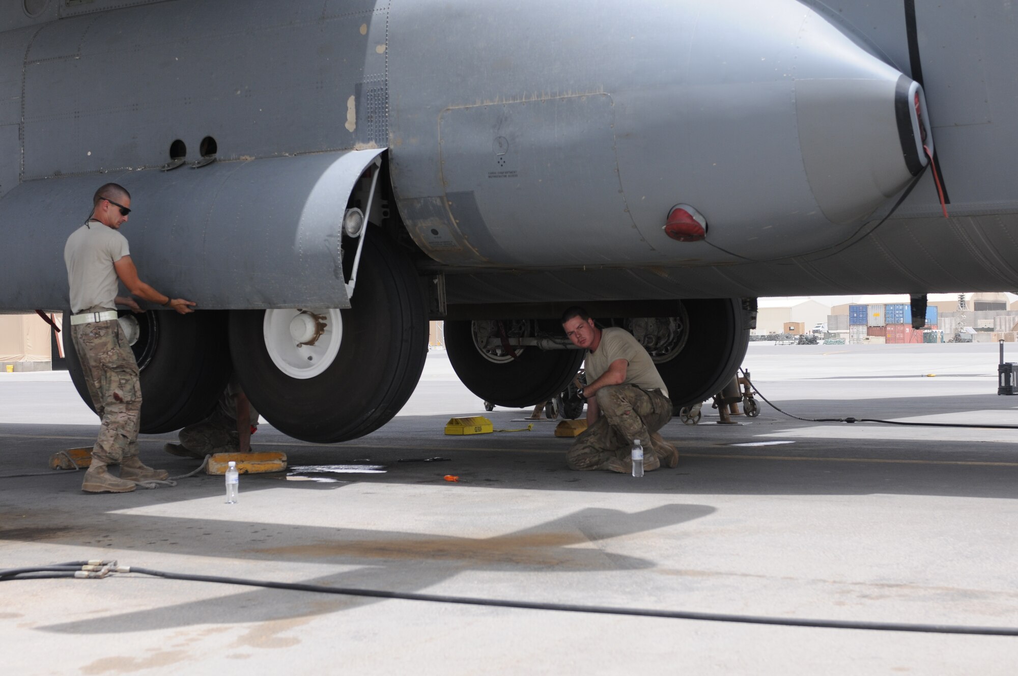 Staff Sgt. Daniel Ward and Senior Airman Zachary Moore finish maintenance on a C-130J Super Hercules that was raised on jacks at Kandahar Airfield, Afghanistan, July 17, 2013. The Airmen were working to repair a brake line. They are both assigned to the 451st Expeditionary Aircraft Maintenance Squadron and are deployed from Little Rock Air Force Base, Ark.  Ward is a native of Great Falls, Mont., and Moore is a native of Pickerington, Ohio. (U.S. Air Force photo/Capt. Brian Maguire)