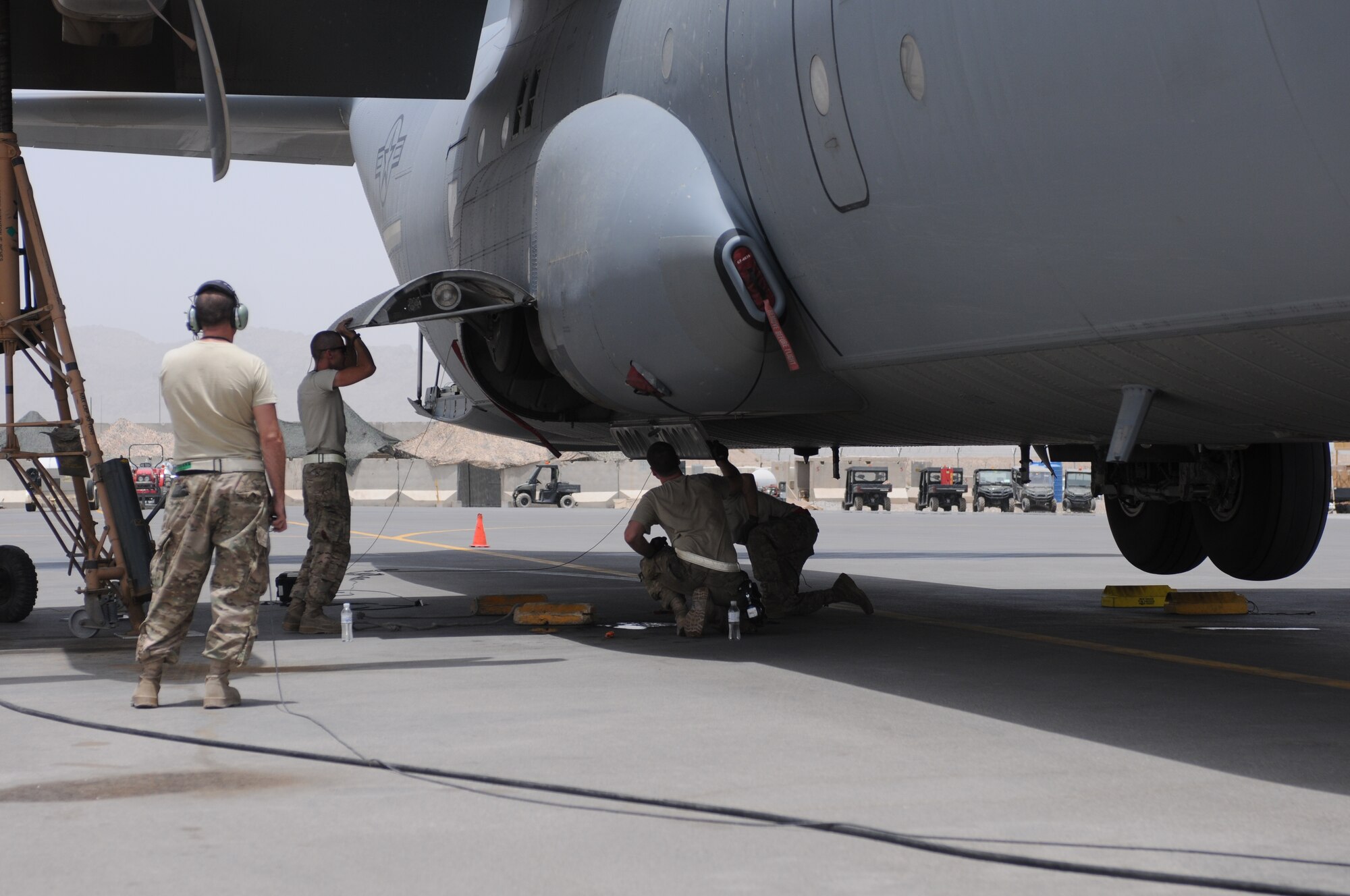 Tech. Sgt. Christopher Gordon, Staff Sgt. Daniel Ward, and Senior Airmen Zachary Moore and Andrew Kaercher, work on the brake line of a C-130J Super Hercules at Kandahar Airfield, Afghanistan, July 17, 2013. The Airmen had to raise the C-130J on jacks to access the area and test the landing gear. All four are assigned to the 451st Expeditionary Aircraft Maintenance Squadron and are deployed from Little Rock Air Force Base, Ark. Gordon is a Hartselle, Ala., native, Ward is a Great Falls, Mont., native, Moore is from Pickerington, Ohio, and Kaercher is from Tuscon, Ariz. (U.S. Air Force photo/Capt. Brian Maguire)