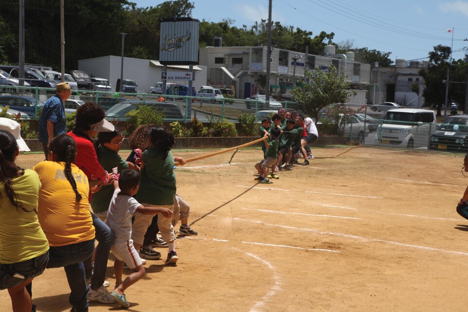 Two teams compete in a game of tug-of-war July 13 at the Busy Bee International Japanese Elementary School during the 2nd Annual Friendship Day Picnic. “It helps bring an understanding of (Americans) to the children,” said Michael B. Martin, a volunteer at the school. “The children know the American military is here, but they don’t know much about them.” Photo by Lance Cpl. David N. Hersey