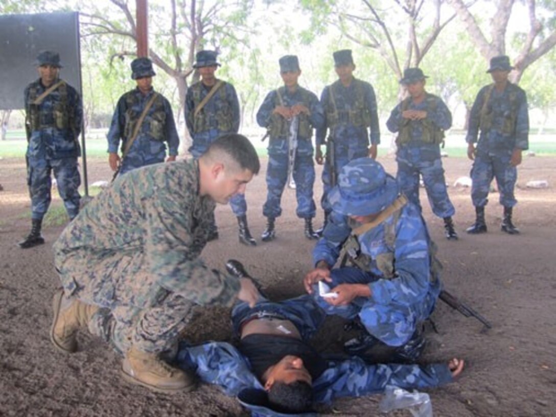 U.S. Navy Hospital Corpsman 3rd Class Jon Garica, a corpsman with the Security Cooperation Team from U.S. Marine Corps Forces South, observes a Marine from Tropa Naval Nicaragua apply bandages to a simulated casualty during a first-aid class, May 21.  The Security Cooperation Team trained 24 Marines with the Tropa Naval Nicaragua from May 18 through June 9 in a variety of military classes , including human rights, first aid, small-unit leadership, and weapon-systems marksmanship. (Official Marine Corps photo: Courtesy//Released)