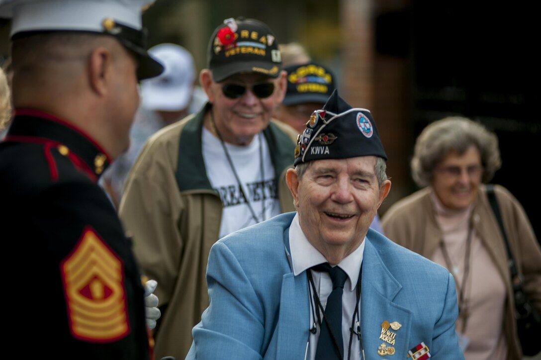 Master Gunnery Sgt. Thomas Franco, Marine Barracks Washington, D.C. ceremonial hoster, greets guests before the start of a parade, in remembrance of the Korean War, at the Barracks July 25. 